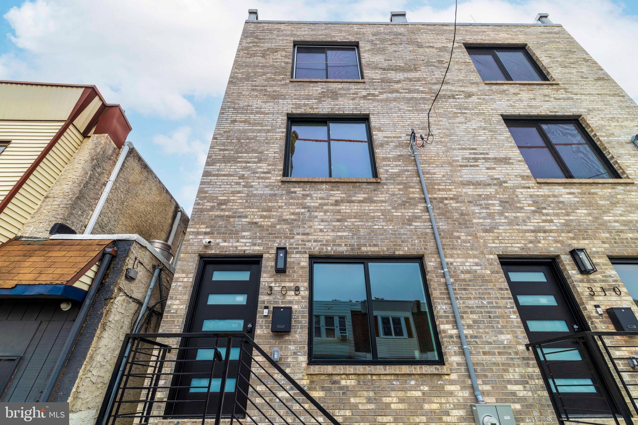 A Stunning Custom-Built New Construction Home in South Philadelphia! This thoughtfully designed residence offers the perfect blend of modern elegance, smart home technology, and high-end finishes—complete with a 10-year tax abatement and a 1-year builder’s warranty for peace of mind. Step inside to find a spacious first floor featuring a bright living room with a cozy fireplace, an open staircase with sleek glass railings and step lighting, and a dining area that flows seamlessly into the gourmet kitchen. The chef’s kitchen boasts a waterfall quartz island, stainless steel appliances, under-cabinet lighting, and sliding doors that open to the private backyard—ideal for entertaining. The second floor offers two generously sized bedrooms, a full bathroom, and a convenient laundry area. Upstairs, the private third-floor primary suite impresses with cove lighting, a walk-in closet, and a luxurious spa-like bathroom complete with a freestanding soaking tub, a walk-in shower, and a double vanity. Take the staircase up to the rooftop deck, where glass railings frame breathtaking panoramic views of the city skyline. The finished basement expands your living space with a full bathroom and stand-up shower, making it perfect for a guest suite, home office, or gym. This home is equipped with smart home features, including built-in speakers, an exterior security camera, and a Wi-Fi–enabled dual-zone HVAC system for maximum comfort and convenience.