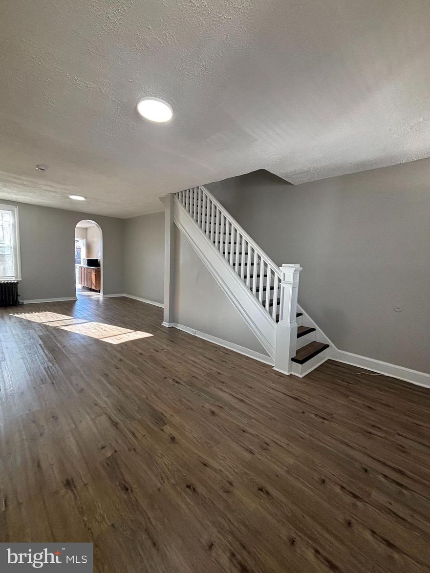 Experience the perfect blend of historic charm and modern living in this  charming end-of-unit rowhome. Situated on a quiet, peaceful block directly across from a community green space, this home offers a serene retreat while keeping you minutes away from the heart of the city. Step into an expansive open floor plan featuring soaring high ceilings and beautiful hardwood flooring throughout. Fall in love with the unique archways and a cozy fireplace that serves as the centerpiece of the living area. As an end-of-group home, you’ll enjoy an abundance of light in every room, complemented by a fresh, neutral paint palette. In addition to three spacious bedrooms, the dedicated den is perfect for a home office, hobby room, or nursery.
Features plenty of prep space and leads directly to a private rear deck—ideal for morning coffee or weekend grilling. Provides extra living space for a media room or gym, plus plenty of storage.Laundry Made Easy: In-unit washer and dryer included.Enjoy the quiet neighborhood vibe without sacrificing convenience. You are perfectly positioned for a 15-minute commute to: Morgan State University, Downtown Baltimore & Fells Point.