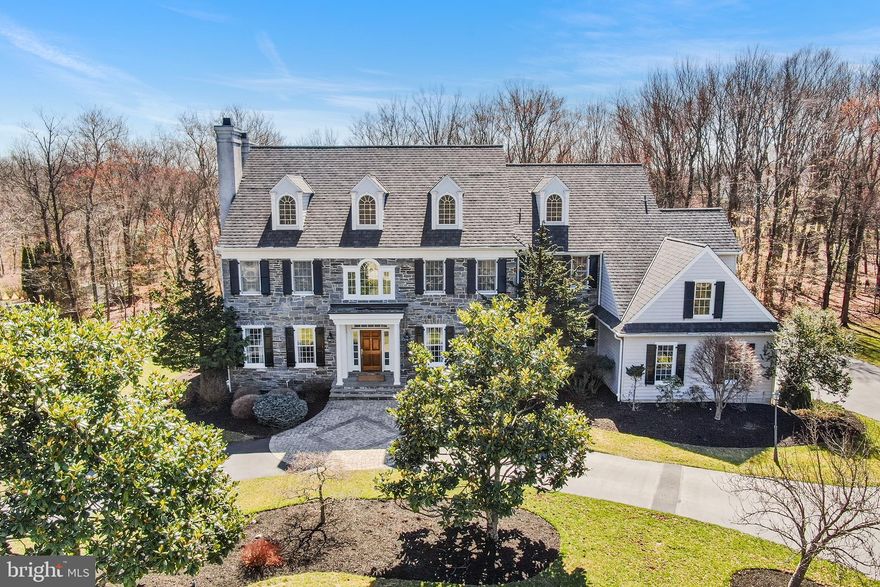 Nestled on 2.6 picturesque acres in the prestigious Dovecote Lane neighborhood, a private cul-de-sac of just 10 homes, this custom-built 2000 home blends timeless elegance with modern comfort. A grand circular driveway leads to a stunning entryway, where a front-to-back foyer with an elegant staircase sets the stage. The formal living room features a cozy gas fireplace, while the dining room showcases intricate woodwork. A well designed butler’s pantry provides seamless access to the kitchen and back staircase.

The kitchen offers abundant cabinetry, generous counter space, an island with seating for four, and a built-in desk area. The sunlit breakfast room overlooks the serene backyard and opens to a flagstone patio with a built-in gas grill—perfect for outdoor entertaining. The inviting family room boasts a coffered ceiling and a wood-burning fireplace, while the first-floor office with custom built-ins features a third gas fireplace. Additional conveniences include an oversized formal powder room, a mudroom with a secondary powder room, and a three-car garage.

Upstairs, the primary suite offers a sitting room, his-and-hers walk-in closets, and a spa-like bath with dual vanities, a walk-in shower, and a soaking tub. Two bedrooms have private en-suite baths, while the remaining two share a hall bath. A dedicated laundry room completes this level. The back staircase leads to a third-floor attic, offering potential for additional living space, while the over 2,500 sq ft unfinished basement provides room for ample storage and future expansion.

Meticulously maintained with an updated HVAC system, newer roof, and in-ground sprinkler system, this home is just minutes from the borough of Malvern, with boutique shops, restaurants, Amtrak and R-5 train service, and easy access to major highways and Philadelphia International Airport.