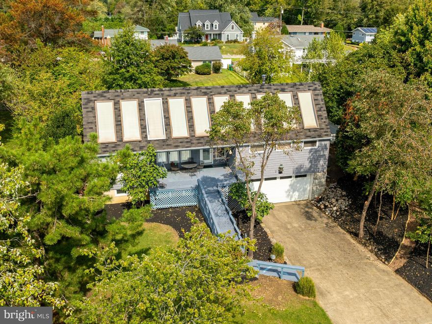 Rare Contemporary home now for sale for the first time in decades, located in the highly desirable Hillsmere neighborhood, directly across from the Chesapeake Bay with stunning water views. Originally designed with a passive solar heat source, the property has also been equipped with a heat pump and central HVAC for enhanced comfort.

The beautifully landscaped yard features a former vegetable garden and mini orchard in the back, as well as a variety of flower bulbs and trees in the front.

Inside, the home includes a great room with a cathedral ceiling that seamlessly connects the living room, dining area, and kitchen. The layout offers access to the bedrooms, a back sunroom, a green room, and a spiral staircase leading to a loft with water views.

This residence comprises three bedrooms, two and a half bathrooms, a family room with a wood-burning stove, a spacious laundry room, a primary suite, an unfinished basement, and an oversized two-car garage. Additional features include a large front porch, walkout basement, interior access to the garage, a backup generator and ample storage options in both the basement and a back storage room accessible via side stairs.

Hillsmere residents benefit from community amenities, including a beach, boat ramp, playground, pavilion, and potential pool membership. The home is conveniently located near Quiet Waters Park, restaurants, shops, and historic downtown Annapolis. Don’t miss this rare opportunity to own a thoughtfully designed home in a prime location.