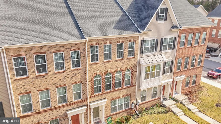 Welcome to 12918 Rustic Rock Lane, a beautifully appointed brick-front townhome perfectly positioned within the highly sought-after Brickyard Station community in Beltsville — where timeless design, modern convenience, and effortless commuter living converge. Facing a lush, manicured courtyard that creates a charming and welcoming first impression, this residence offers refined curb appeal complemented by a rear-loading two-car garage and private outdoor deck, delivering both function and elegance in equal measure. Step inside to sun-drenched interiors enhanced by hardwood flooring, a fresh designer paint palette, and thoughtfully curated spaces designed for today’s lifestyle. The inviting foyer introduces a versatile entry-level bedroom complete with its own ensuite bath — ideal for guests, multigenerational living, or a private home office — along with direct access to the spacious two-car garage. Ascend to the heart of the home where engineered hardwood flooring flows seamlessly throughout an expansive main living level crafted for both everyday comfort and elevated entertaining. The chef’s kitchen serves as the centerpiece, showcasing stainless steel appliances, 42” Snow White cabinetry, granite countertops, pendant lighting, and generous preparation and gathering space that effortlessly brings people together. To one side, a welcoming living area opens to a private balcony — perfect for morning coffee or evening unwinding — while the opposite side reveals a grand dining space framed by elegant palladium windows that flood the home with natural light. A well-appointed powder room completes this thoughtfully designed level. The upper level offers a serene retreat highlighted by a luxurious owner’s suite featuring sunlit interiors, a spacious walk-in closet, and a spa-inspired ensuite bath with double vanities, an oversized walk-in shower with built-in seating, and a private water closet. A secondary suite, complete with its own ensuite bath and built-ins, provides comfort and privacy rarely found in townhome living. Brand-new paint and carpet throughout create a truly move-in-ready experience. Beyond the home itself, Brickyard Station delivers an unmatched lifestyle with beautifully maintained green spaces, playgrounds, walking paths, and community gathering areas designed to foster connection and convenience. Commuters will appreciate the unbeatable proximity — just a short walk to the MARC Train Station — providing seamless access to Washington, D.C., Baltimore, and surrounding employment hubs. Moments from major commuter routes including I-95, Route 1, and the ICC, as well as shopping, dining, and everyday conveniences, this location balances suburban tranquility with urban accessibility. Homes offering this level of design, condition, and commuter convenience rarely become available — presenting a compelling opportunity for buyers seeking both lifestyle and long-term value. Move quickly, because homes in Brickyard Station with this level of finish and location do not last.
