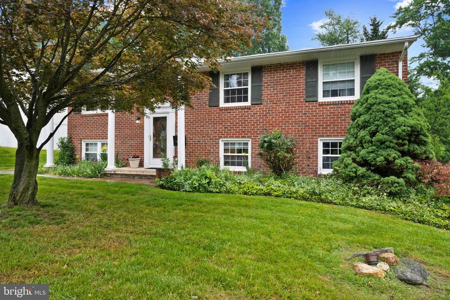 Nestled at the end of a quiet side road and surrounded by the peaceful beauty of nature, this exceptional split-level home offers the perfect blend of timeless charm, thoughtful updates, and expansive living space. Lovingly cared for and meticulously maintained by the same owner for 30 years, every inch of this home reflects pride of ownership and attention to detail. From the moment you step inside, you are welcomed by gleaming hardwood floors and an airy, light-filled main level designed for both comfortable everyday living and effortless entertaining. The expansive open concept living and dining rooms create an inviting atmosphere, with oversized windows that fill the space with natural light and a seamless flow that leads directly into the beautifully renovated kitchen and out to the oversized deck beyond.  The kitchen is both stylish and functional, featuring rich walnut-toned cabinetry, elegant granite countertops, stainless steel appliances, and a charming built-in breakfast table that creates the perfect setting for morning coffee, casual meals, or late night conversations. Just down the hall are two generously sized secondary bedrooms, each offering ample closet space and easy access to the well-appointed hall bath.  The true centerpiece of the home, however, is the remarkable primary suite retreat created through a thoughtfully designed two-level addition. This private sanctuary feels like something out of a luxury boutique hotel, offering an incredible amount of space and comfort rarely found in homes of this style. The suite features an enormous custom walk-in closet system designed to accommodate even the most extensive wardrobe collections, a relaxing sitting area ideal for reading or unwinding at the end of the day, and a beautifully expanded bathroom that provides a spa-like experience right at home.  The lower level continues to impress with versatile spaces designed for entertaining, relaxing, and working from home. The addition creates a separate family room currently used as a sophisticated bar and gaming lounge, perfect for hosting friends and family. The spacious recreation room offers endless possibilities whether you envision unforgettable Ravens watch parties, cozy movie nights, a play area, or a media room. A full bathroom on this level adds convenience, while the dedicated office provides a quiet and functional work from home setup. Even the finished storage room has been thoughtfully designed and could easily serve as a craft studio, fitness room, playroom, or additional flex space to suit your lifestyle.  Step outside and discover a backyard setting that feels like a private nature retreat. The expansive deck overlooks a beautifully tiered two-level backyard, creating multiple areas for entertaining, gardening, or simply enjoying the peaceful surroundings. At the rear of the property, a gentle stream winds its way through the landscape, adding a tranquil backdrop and completing this truly special outdoor oasis. This is more than just a home it is a warm, inviting retreat where memories have been made for decades and where the next owner will instantly feel at home. **Playset is as-is**