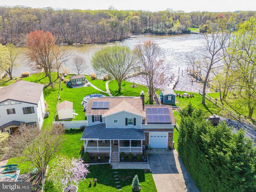 Welcome to this beautifully renovated four bedroom, two bathroom waterfront colonial offering breathtaking views and thoughtful upgrades throughout. Step inside to an open-concept main level with a gorgeous new kitchen - complete with cream cabinetry, stainless steel appliances, granite countertops, gas range, island with breakfast bar, and stylish backsplash - that seamlessly flows into a spacious great room. Enjoy cozy evenings by the wood stove or pellet stove while taking in the serene water views. The main level bedroom, full bathroom and laundry adds convenience.

Outside is your own private paradise: From the stamped concrete patio, partially fenced rear yard, hot tub and a 60-foot double bulkhead with pier, boat lift, and oversized garage with drive-through access for boats. Plus, there’s a charming party shed with retractable awning - perfect for entertaining!

Additional features include a walk-in attic for storage, 2024 HVAC system, and solar panels for energy efficiency. This is waterfront living at its finest—don’t miss your chance to own this exceptional home!