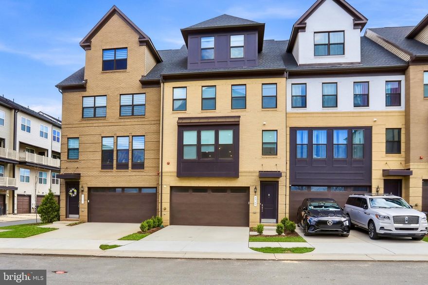 Welcome to 4965 Longmire Way, an exceptional four-level townhome in the highly sought-after Boulevards at Westfields, where modern luxury meets effortless living. Built in 2023 by K. Hovnanian, this stunning Bennington II model offers over 3,100 square feet of thoughtfully designed space, featuring 5 bedrooms, 4 full baths, 2 half baths, and a 2-car garage.

From the moment you enter, you’re greeted by a bright, open-concept main level designed for both everyday living and elevated entertaining. The expansive great room flows seamlessly into the dining area and chef’s kitchen, creating a warm yet sophisticated gathering space. The kitchen is beautifully appointed with Absolute Black granite countertops with a leathered finish, premium cabinetry, and modern finishes. A sun-filled Florida room and multiple private balconies provide the perfect places to relax, unwind, or entertain.

Luxury vinyl plank flooring extends throughout the main and upper levels, complemented by custom automatic roller blinds that add both style and convenience. Every detail has been thoughtfully curated to deliver a clean, modern aesthetic.

The upper levels offer a spacious and flexible layout, including a serene primary suite and generously sized secondary bedrooms. The top-level loft provides a versatile retreat—ideal for a home office, media room, or private lounge—while offering access to additional outdoor living space.

The fully finished lower level enhances the home’s livability with abundant natural light, daylight windows, and multiple access points including garage entry, a private exterior entrance, and walkout access—perfect for guests, recreation, or multi-generational living.

Ideally located in Chantilly, this home is just moments from Eleanor C. Lawrence Park, where scenic trails, sports fields, and green space await. Enjoy convenient access to premier shopping, dining, and entertainment, along with easy commuting via Route 28, Route 50, I-66, and Dulles International Airport.

Offering an exceptional blend of space, style, and location, this nearly new home delivers the ultimate in luxury, comfort, and convenience.