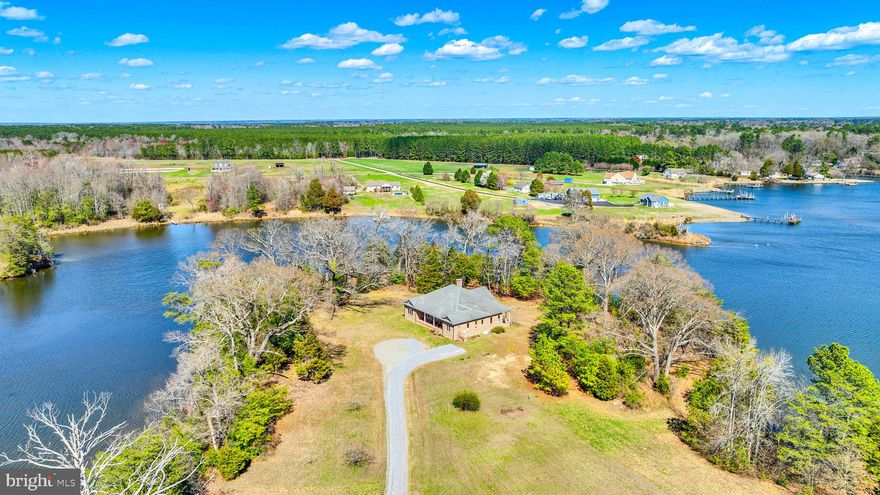 Welcome Home to the property affectionately known as TRAVELERS REST. Whether you are looking for a 165 acre farm or you're looking for a magnificent waterfront home, you get it all right here in this serene slice of heaven.  Let's start with the home... This custom built, brick rambler will impress the moment you walk in, when all of your attention is drawn to the gorgeous wall of windows showcasing the water views. Not to be overshadowed by the incredible, vaulted, tongue and groove pine ceiling, floor to ceiling stone fireplace, custom mantle,  and the French door on either side of those windows to access two covered porches. The main living area is the perfect open floor place to keep everything together and simple. The kitchen has custom cabinetry, granite countertops and a bar style island, while still having an eat-in area that is big enough to fit your dining room table. The home has two generous sized secondary bedrooms and a full bathroom to the right of the main living area. To the left is the den and primary suite with water views and it's own access to the porch. The home has a concrete floored conditioned crawlspace that houses the Geothermal 4 Zone HVAC System (with transferable 10 year parts and 5 year labor warranty), the Water Conditioning/Softener System and a 50 gallon water heater.  Now for the outside... If waterfront is what you're looking for then look no more. Over one half of a mile of water frontage and a pier with a mean low water depth of 2.8' at the end. There is a huge (56'x44') red barn/workshop with 14' clearance complete with a rebar reinforced concrete floor. 165.42 acres zoned agricultural except the 1 acre for home site. 70 of these acres are currently farmland (renewable lease with farmer) as well as an enclosed 17 acre pasture with automatic livestock waterer.  This property has no HOA or restrictions. Make your dream a reality.