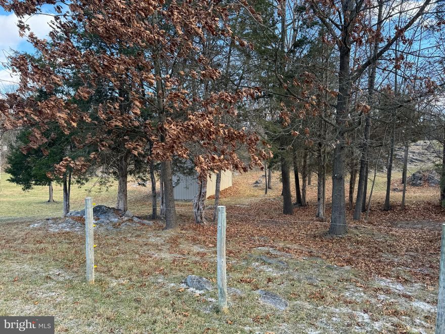 The property at 318 Comstock Drive in Shepherdstown, WV, is a 2.74-acre piece of land located in the Potomac River Farms subdivision. It is within walking distance of community access to the Potomac River and about 10 minutes from Shepherdstown's downtown area, known for its dining and shopping options. The property features a 12x36 horse barn with electric previously used for two horses, a three-bedroom septic system recently recertified, and about one acre enclosed by an unused electric fence.  Recent improvements include an updated electric panel in the barn, new doors on the barn, and clearing and cleaning up of the lot.   It offers significant potential for building a primary or vacation home in a serene environment