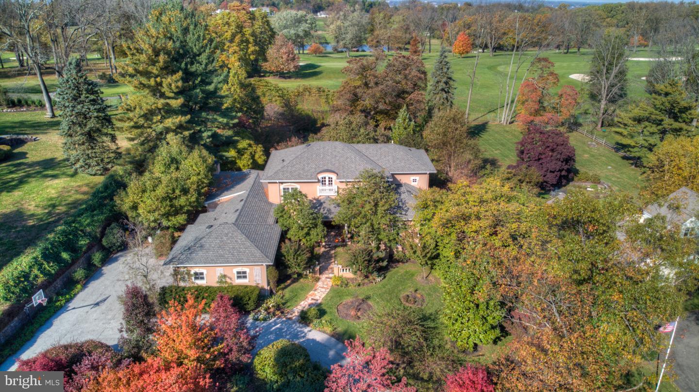 Is living on a golf course your dream? the time has come for you to take a look at this unique home on Philadelphia Country Club s 3rd Fairway. It was custom built for the current owner. Its Open Floor Plan is conducive to today s style of living and perfect for entertaining inside and out. An elegant Foyer with curved staircase and soaring ceiling invites you to explore the truly fine craftsmanship that emanates throughout this home. Arched Doorways, Transom Windows, French Doors, Coffered Ceilings, and Exquisite Moldings are just a few of the architectural features that grace this home. For those who enjoy the warmth of a fireplace, there is one in the Living Room, Library, Family Room and Master Bedroom. There are Hardwood floors throughout and Radiant Heated Floors on the 1st Floor. Outside Living is maximized with a Covered Porch, Flagstone Patio and beautiful landscaping. The Gourmet Kitchen is a cook s delight with 5 burner gas Thermidor cooktop, Double Wall Oven, Custom Island with Breakfast Bar and built in China cabinet. Sip your morning coffee while enjoying the birds and the changing landscape in the sunny Breakfast area with French doors to a private garden. There is a large Pantry Closet with a convenient pass through to the kitchen, back Mud Room coat closet and 2nd Powder Room which can be accessed directly from the attached 2 car garage or from the side garden entrance. Not to be missed is the First Floor Master Wing. The Master Bedroom is complete with raised hearth fireplace, oversized transom windows, His and Her walk-in closets with built-in cabinetry, an elegant Marble Bath with Stall Shower, Separate Whirlpool Tub and Double Vanity. Radiant Heated Floors and a Private Office with built-in bookshelves complete this very special Master Suite. The 2nd Floor overlooks the Foyer and includes 3 Bedrooms each with ensuite bath plus a 2nd Floor PlayRoom/Family Room with French Doors to a Sun Porch which enjoys a bird s eye view of the golf course. Bright and spacious, Walk Out Lower Level includes a Full Bath, Laundry Room, Exercise Area, Entertainment Space, and Storage.