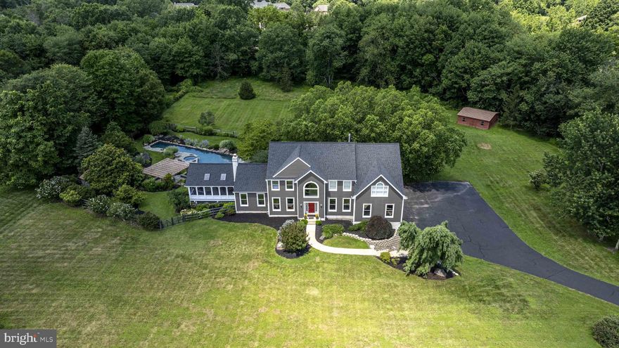 This exceptional, meticulously maintained residence is nestled on 4.21 acres in the award-winning Central Bucks School District, offering the perfect balance of privacy, luxury and convenience. Featuring 4 bedrooms, 3 full and 2 half baths, a 3-car garage, and countless upgrades, this custom-built home is ready for its next steward. As you arrive, a long private driveway leads you to the home’s stately presence, framed by professionally landscaped grounds and new exterior siding. Step inside to a dramatic 2-story marble foyer flanked by a formal living room and a dining room—ideal for entertaining. At the heart of the home, the kitchen impresses with a large center island, granite countertops, stainless steel appliances, an abundance of cabinetry, and a walk-in pantry. The kitchen flows seamlessly into the breakfast room with a soaring 2-story ceiling and walls of windows that bathe the space in natural light. Just beyond, the family room invites with a woodburning fireplace, vaulted ceilings, and back staircase access. French doors lead to an incredible 450+ sq ft sunroom—a year-round retreat. The recreation room provides the perfect venue for gatherings, featuring custom built-ins and surround windows for panoramic views of the property. Work from home with ease in the private office with custom built-ins. The first floor also includes a laundry room with custom cabinetry and utility sink, a powder room, and remote-controlled blinds for added convenience and privacy. Up the turned staircase, the primary suite is a true sanctuary with a tray ceiling, sitting area, two walk-in closets with closet organizers, and a luxurious bathroom complete with soaking tub, dual vanities, shower stall, and private water closet. The upper level also offers an en-suite bedroom, two additional bedrooms, and a hallway bathroom. The finished walk-out lower level is a flexible space for a home gym, game room, or recreation area—complete with a kitchenette, half bath, and direct access to the backyard. Step outside to your personal resort-style backyard featuring an LPE hardwood deck, extensive custom bluestone patio, newly updated pergola, and a breathtaking custom heated pool with spa, boulder features, and tranquil design. The sprawling backyard offers endless possibilities for outdoor fun and relaxation. Additional features include whole-house generator and newer roof (2021), across the street from the township walking trail and minutes to Peace Valley Park and Doylestown Borough’s dining, shopping, and cultural attractions. Don't miss this rare opportunity to own a stunning, move-in-ready estate in one of Bucks County’s most desirable locations. Schedule your private tour today and make 340 West Sandy Ridge Road your forever home.
