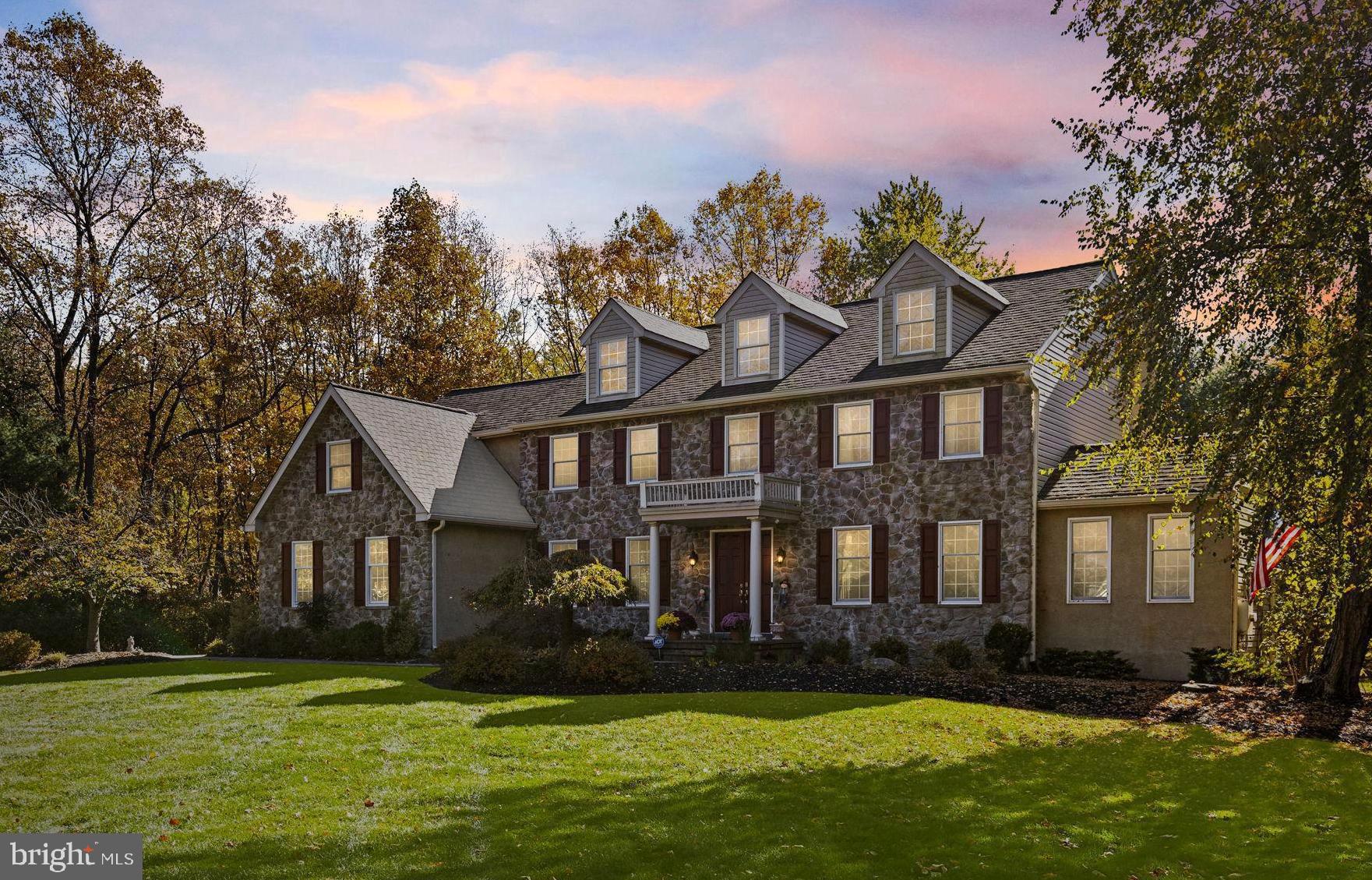 Within the northeastern reaches of Ambler, tree-lined streets snake their way through charming neighborhoods of beautiful homes. Here you’ll find a lovely cul-de-sac of 8 homes and nestled on the corner as the gateway to the street sits a handsome center hall Colonial full of stately splendor on almost 1.5 acres of lush grounds. As you pull into the driveway, a little smile creeps across your face. There it is—your house—standing proud with its traditional stone front, charming dormers, and the front door flanked with pillars below a Juliet balcony. The manicured landscaping is a fitting invitation, silently promising peace and quiet. Here, you’re not just stepping into a house—you’re entering a world where every detail has been carefully considered and impeccably executed.
A grand foyer with elegant Botticino marble flooring, crown molding, a powder room, and a sweeping staircase greet you and through French doors at the end of the foyer, you glimpse a sea of lush, green landscaping. You enter the formal living room which flows into the cozy family room, its marble fireplace inviting you to have a seat and relax and dream of cozy winter evenings in front of the fire. You admire the soaring windows and think that even you can keep plants alive in this home. Finishes here rival the most luxurious new development. You’ll be the envy of your colleagues on your work Zoom calls, you chuckle to yourself, as you enter the library with its built-in bookshelves and cathedral ceilings. You continue to the dining room with its crown molding and wainscoting and imagine it filled with the laughter of family and friends at your famous dinner parties.
Now for the kitchen. The true pièce de resistance. It’s the kind of gourmet chef’s kitchen that makes you believe you might actually enjoy cooking, or at least you’ll look good doing it. Every detail throughout has been meticulously chosen to create a timeless design. Featuring custom Shaker cabinetry with brass Top Knobs hardware and a crown molding frame, this space is truly magazine-worthy. Sub Zero, Wolf, and Cove appliances including a Wolf coffee station? Check. Black Coral quartz countertops juxtaposed with a delicate Hampton Brookfield marble backsplash? Check. A massive island with Montauk quartz countertops and a custom walk-in pantry and drop station? Check and check.
Upstairs, the sun-soaked primary suite merges classic charm with modern influences and the innovative design of a five-star hotel, creating a truly inspirational sanctuary. Mahogany floors, a vaulted ceiling, and a gas fireplace make it almost too good to leave. Its spa-like bath boasts radiant marble floors, two vanities, a freestanding vintage-inspired soaking tub that’s practically begging for bubble baths, and an oversized marble shower. A separate water closet allows for privacy. The closets? Here you’ll find two enviable custom walk-in closets that raise the standard from ordinary closets to boutique-like spaces completely with laundry. This bedroom is everything you'd expect from a home of the highest caliber. Rounding out the floor are three additional sunny bedrooms, one with an ensuite bathroom and two connected with a Jack-and-Jill.
And just when you think you’ve seen it all, the finished waterproofed basement with French drain wows you one more time. It’s not just a basement—it’s an escape. With a second kitchen, a cozy fireplace, and even a full bath, it’s like your favorite hangout spot just moved in with you.
Lastly, the yard. EP Henry patios, built-in planters, and pathways so polished you could host a garden party tomorrow and still have time to pick out the perfect outfit.
This isn’t just a house; it’s the backdrop for your life’s next chapter. It’s where milestones happen, where weeknight dinners become memories, and where the little things—like warm floors underfoot or sunlight pouring into your family room—remind you why you’re here.