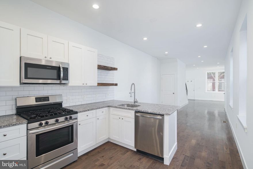 Introducing 1737 N. 28th Street! Enter from a quiet, tree-lined block to this remarkable renovation featuring a spacious living room, open dining area and kitchen, and half bath. Hardwood floors impress upon entry. Abundant windows bring in natural light. In the kitchen you'll find ample cabinet space with soft-close shaker cabinets, stainless steel appliances, and open shelving. Rear patio and yard perfect entertaining and pets. On the second floor you'll find three bedrooms, a full bath with oversized vanity, and a laundry room. On the third floor, a charming primary bedroom suite with pass-through closet to a private full bath. Full, unfinished basement perfect for storage. Rare to find this much space at this price. Schedule your private showing today!