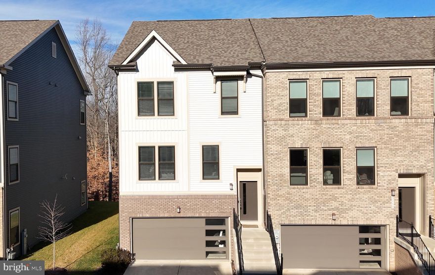 Welcome to 3238 Watershed Blvd, a rare end-of-group residence perfectly positioned on a premium lot backing to serene forest views—where thoughtful design, natural light, and lifestyle-driven living converge. A brick water table, architectural shingles, front-loading garage, and professionally curated landscaping create striking curb appeal, while the side yard and wooded rear setting offer a level of privacy seldom found. Step inside through the sunlit foyer and ascend to an expansive open-concept main level designed to impress and perform. Fresh paint, brand-new carpet, and a soft neutral palette create an immediate sense of warmth and refinement, while strategic bump-outs add valuable square footage and enhance flow. The family room feels light and airy with recessed lighting and window treatments, seamlessly connecting to a generous dining area accented with hardwood flooring—ideal for hosting memorable gatherings. At the center of the home, the chef’s kitchen delivers both beauty and function. Quartz countertops, 42” Snow White cabinetry with elegant black hardware, and a stunning oversized island anchor the space. Stainless steel appliances include a gas-powered range with double oven, microwave, and refrigerator, while a deep stainless sink with forest-facing views turns everyday moments into something special. Thoughtful additions like a walk-in pantry, built-in coffee nook, and statement black pendant lighting elevate the experience. Just beyond, the sunroom—wrapped in windows—invites relaxation and opens via sliding doors to your future deck, perfectly positioned to enjoy the tranquil wooded backdrop. The upper level is a true retreat. The owner’s suite is expansive and serene, featuring abundant windows, a ceiling fan, and two oversized walk-in closets. The ensuite bath feels spa-inspired with double vanities, a full-width mirror, and a frameless glass shower with dual black shower heads and built-in seating. Two additional spacious bedrooms, a full hall bath with espresso cabinetry, a dedicated laundry room, and a versatile study nook complete this level with comfort and intention. Downstairs, the finished lower level expands your living options with brand-new carpet, recessed lighting, and a private fourth bedroom—perfect for guests, multigenerational living, or a home office. A walk-out leads directly to the backyard and surrounding greenery, while a conveniently located half bath, access to the oversized garage, ample storage, and a 200 AMP electrical panel add everyday practicality. Set within the highly sought-after Watershed community, residents enjoy an amenity-rich lifestyle including a resort-style pool, clubhouse, fitness center, playgrounds, trails, and beautifully maintained common areas—designed to foster connection and convenience. Ideally located near major shopping centers with favorites like Target, Walmart, and a wide array of dining options, this home also offers effortless access to NSA Fort Meade and major commuter routes including 32 and 295. Whether you’re heading to work or enjoying a night out, everything you need is just minutes away. Homes that combine premium lot positioning, refined interiors, and a true community lifestyle rarely come available. 3238 Watershed Blvd is not just move-in ready—it’s the opportunity you’ve been waiting for.