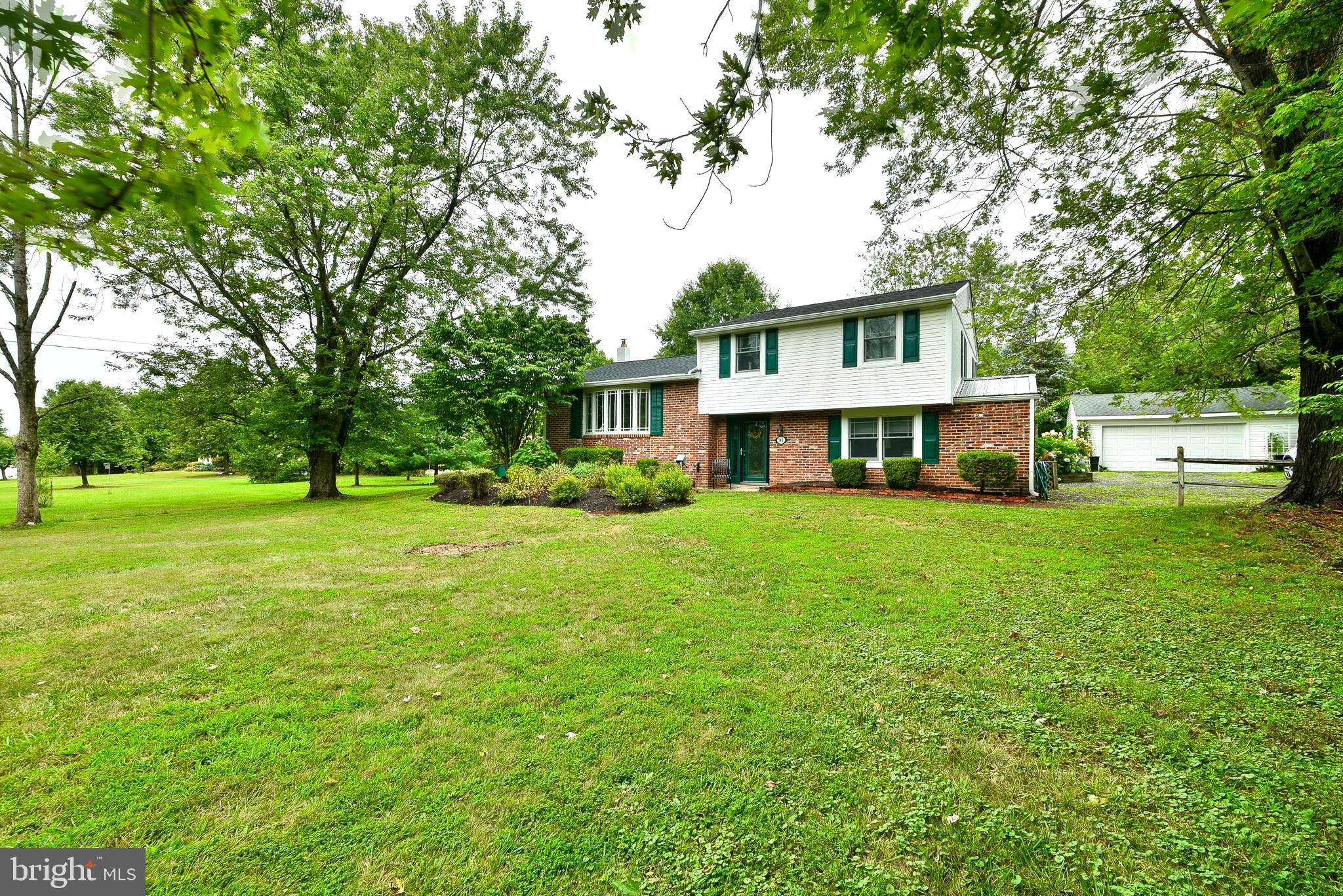Don't miss your opportunity to tour this charming split-level home in Tinicum Township, Bucks County.  This property sits on a generous 1.26-acre lot and reflects pride of ownership throughout. The property is beautifully landscaped and offers a high degree of privacy. Inside, you'll find three bedrooms (with hardwood floors), one and a half bathrooms, a living room, two family rooms/dens and a basement.  The recently remodeled kitchen is a highlight, featuring stunning cabinetry,  quartz countertops, a custom full-wall pantry system, and a large island that opens to the living and dining areas. Perfect for entertaining. All windows are double hung  Anderson with upgraded internal grids and the front bow window is a Pella with 5 casements ... all open with screens.  In 2023, the exterior of the home was updated with a new roof, gutters, and fresh paint. The entire interior was also repainted in the same year. The rear patio is designed with a retaining wall and built-in deadman anchors for added stability.  3 Zone Heating. The basement is equipped with a French drain and sump pumps, and includes a generator hookup with plenty of built in storage shelves including a full stand up freezer.  Additionally, there is a detached two-car garage with remote opener and another included refrigerator . This home is very inviting, with thoughtful updates and ample space for comfortable living.   Truly a place to call home.  Palisades School District.