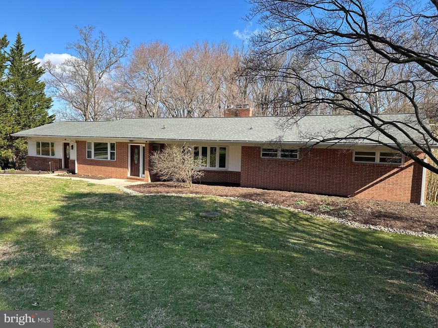 Welcome to 802 Stone Barn Road, a beautifully updated brick rancher set on over an acre in one of Towson’s most established and desirable neighborhoods. Combining classic mid-century character with extensive modern upgrades, this five-bedroom, three-and-a-half-bath home offers space, comfort, and true peace of mind.

Inside, more than 3,300 square feet of finished living space features hardwood floors, exposed beams, skylights, and two fireplaces, creating a warm and inviting atmosphere. From 2024–2026, the home underwent significant renovations, including fresh paint throughout, updated lighting, modernized outlets and switches, and full remodeling of all five bedrooms. Multiple bathrooms have also been renovated, including the half bath, main hall bath, basement full bath, and the primary shower, giving the home a clean, move-in-ready feel.

The fully finished walk-out basement has been completely remodeled and professionally waterproofed, providing flexible space for entertaining, recreation, or multi-generational living. A sump pump system ensures the lower level remains dry and protected year-round.

Major system upgrades further enhance long-term value and efficiency. The home was converted from oil heat to a 500-gallon underground propane system and now features a new furnace, hot water heater, and upgraded copper plumbing. These improvements offer modern reliability and reduced maintenance concerns for future owners.

Outside, the expansive lot offers both privacy and usability. Recent exterior improvements include a new aluminum fence, regrading of the front yard with French drainage, a newly constructed retaining wall, and structural reinforcement above the garage. A screened patio and rear deck provide inviting spaces to relax or entertain while overlooking the spacious backyard.

With its generous layout, over-acre setting, and extensive structural, mechanical, and cosmetic upgrades already completed, 802 Stone Barn Road presents a rare opportunity to own a thoughtfully improved home in a prime Towson location—without the cost or uncertainty of future major renovations.