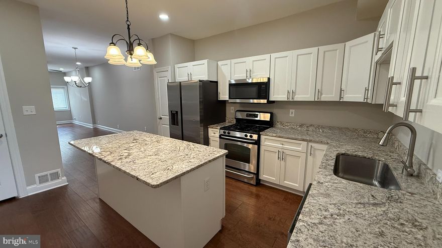 Welcome home to this gorgeous, remodeled rowhome just steps from Patterson Park! The main level showcases wide white-plank wood floors, an airy open layout, and a magazine-worthy kitchen with granite counters, crisp white cabinetry, an island with seating, and direct access to an oversized deck—ideal for morning coffee or sunset dinners. Upstairs, you’ll find three comfortable bedrooms and two beautifully updated full baths, each finished with ceramic tile floors and tiled showers. The finished lower level offers flexible space—think media room, home gym, or office—with the washer and dryer conveniently located toward the rear. Outside, enjoy easy, low-maintenance living with space to relax and entertain. All of this in a stellar location close to Patterson Park, local restaurants, and shopping plazas. Move in, unpack, and start living your city life today.