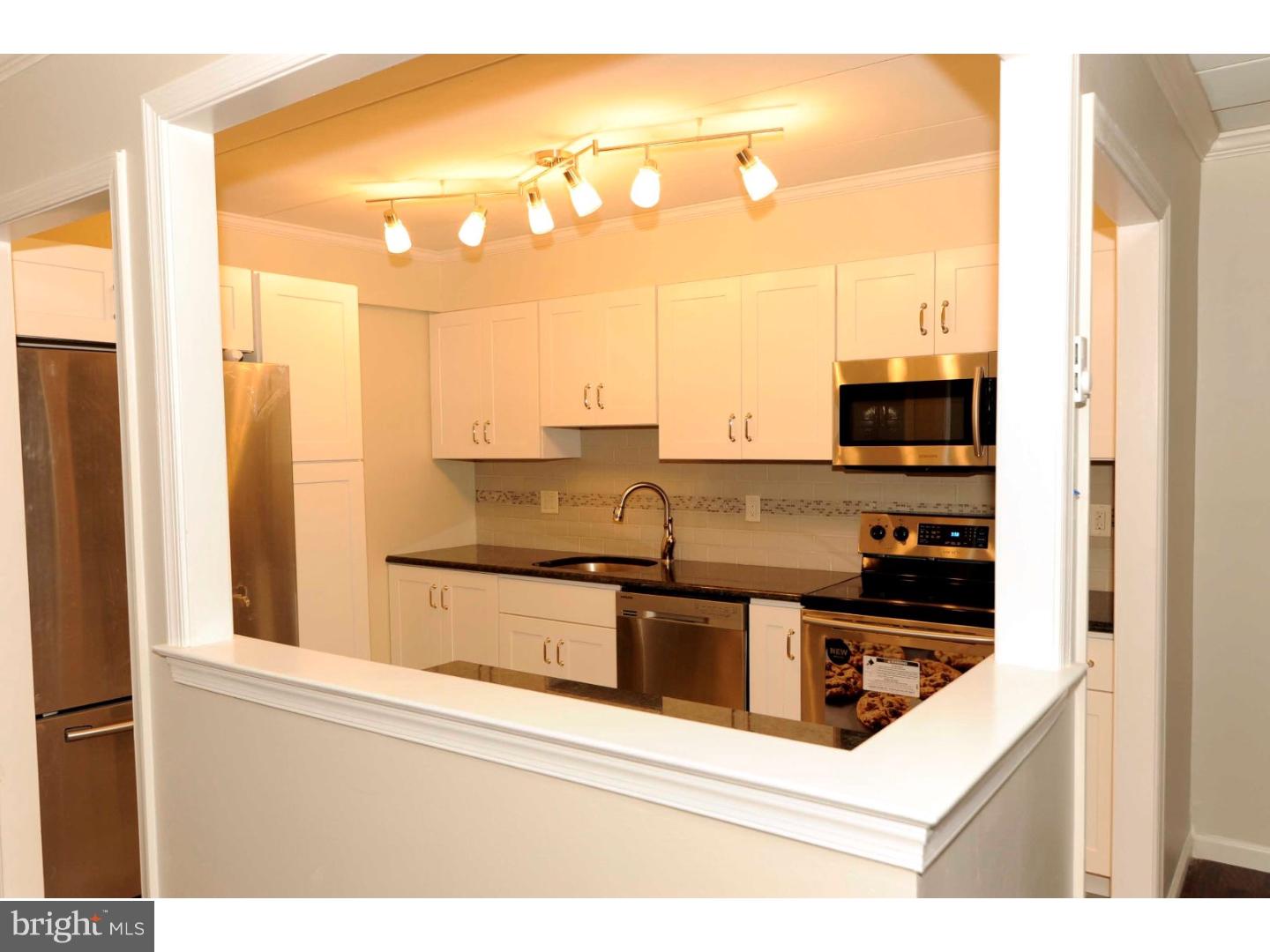 Fully renovated penthouse condo in Haverford Hill with treetop views from your private balcony is ready for you to unpack and enjoy carefree living! An open floorplan offers a brand new modern kitchen with plenty of cabinets, expansive granite counters, glass tile backsplash and new stainless steel Samsung appliances including a 5 burner range with convection oven, French door refrigerator, a 50 decibel stainless steel interior dishwasher and microwave. The kitchen has a modern ceramic tile floor while the expansive living and dining rooms have lovely wood flooring. A large carpeted, master bedroom features a walk-in closet and a private bath with a 4' granite vanity top and a 5' walk-in shower. The second full bath features a tub with subway tile and granite topped vanity. The second bedroom is carpeted with a large closet. Entire unit has crown molding, new 6 panel doors, new youngster proof receptacles and new electric baseboard heat/thermostats. Haverford School District. FHA Approved. Pets allowed. Pool.