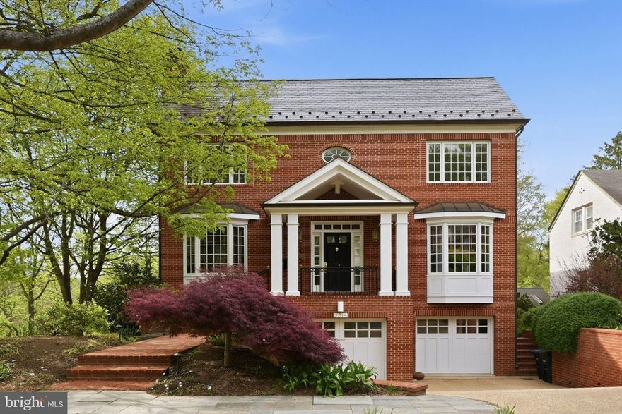 Perfectly positioned on a quiet street in the heart of the Palisades, this all-brick center hall colonial offers a rare combination of privacy, scale, and natural beauty. Designed by award-winning architect David C. Mitchell, the residence is thoughtfully sited alongside U.S. Park Service land, with views toward the Potomac River and the C&O Canal, and direct access to Battery Kemble Park and the Palisades Trolley Trail.

Offering nearly 4,500 square feet of finished living space, the home is defined by its impeccable construction quality and timeless finishes. Warm hardwood floors, custom millwork, high ceilings, and expansive windows fill the interiors with natural light while framing serene, wooded vistas throughout.

The main level is both elegant and functional, anchored by a gracious center hall. A cherry wood-paneled library, which can also be used as a den, features a wood-burning fireplace and creates a warm, inviting retreat, while the formal dining room is well-proportioned for both intimate gatherings and larger-scale entertaining. The rear of the home opens to a well-appointed kitchen featuring a Viking range, Sub-Zero refrigerator, generous island, abundant cabinetry, and a walk-in pantry, seamlessly connecting to the family room and overlooking the surrounding landscape. A full bath on this level adds flexibility for guests or everyday living.

The upper level features three spacious bedrooms, including a private primary suite with dual exposures and tranquil views. The suite offers two walk-in closets and a well-appointed bath, creating a comfortable and refined retreat. Two additional bedrooms, each with excellent light and ample closet space, are served by a large hall bath.

The lower level adds exceptional versatility, with a fourth bedroom and full bath, and a spacious recreation room distinguished by its ceiling height and natural light, with expansive windows that capture beautiful, unobstructed views. The space opens directly to a secluded patio, creating an easy connection to the outdoors. Additional storage and a dedicated laundry room are thoughtfully incorporated on this level.

An oversized, heated two-car garage with built-in shelving and workspace completes the offering.

Set within a uniquely private, park-like setting, this residence offers immediate access to trails and green space, and is within walking distance of the Palisades’ celebrated restaurants, while remaining moments from the conveniences of greater Northwest Washington.