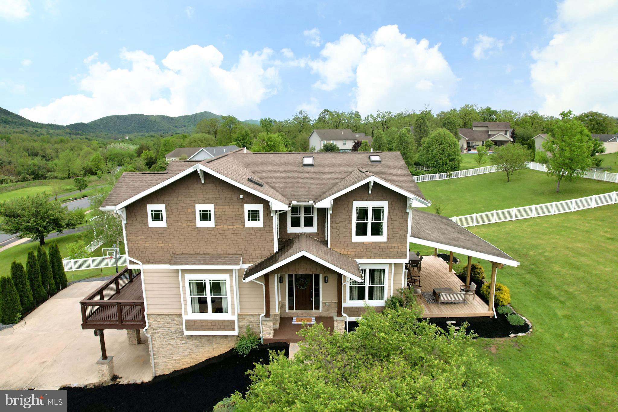 Discover something truly one of a kind at 441 Millgate Road! This lodge-like custom home celebrates the beauty of nature by capturing the incredible mountain views, embracing natural building materials, and allowing abundant natural light through large windows and skylights. You'll love the craftsman feel of this 2013 built two story with 4 beds and 3.5 baths featuring hand hewn maple hardwood floors, wood and stone accents, wide wood trim, craftsman style wooden doors, and stunning two story foyer with slate floors and skylight! Thoughtfully designed common spaces create great opportunities for quiet cozy nights in or grand party hosting. You'll love the formal living room and dining room with stone surround gas fireplace, slate floors, cool candle chandelier, and sliding door to the lovely new covered back deck perfect for summertime BBQs with neighbors and friends. The open concept front of the home frames the stunning views of the mountains with a wall of windows and glass inset wooden doors. Prepare meals to remember in the gourmet kitchen with large island, deep copper farmhouse sink, 5-burner gas cooktop with pot filler and stone surround hood with built-in spice racks, pull-out drawers for pots and pans, two tier silverware drawers, beautiful glass and stone backsplash, wall oven, SS appliances, granite countertops, corner pantry, and much more! Take your first cup of coffee in the charming morning room or on the picturesque front deck as you enjoy the peaceful views of the valley. Host rambunctious game days or snuggly movie nights in the open family room with stone fireplace, play area, hardwood floors, abundant windows, and door to the front deck. Create fun party ambiance with a built-in speaker system throughout the first floor and both decks. You'll appreciate the lovely first floor powder room with copper sink and tile floors. Upstairs you'll find a serene primary suite with large vaulted ceiling bedroom, big walk-in closet with pocket door & built-ins, luxurious private bath with jetted tub with slate surround, stone splash and accents, stone walk-in shower, open design vanity/shelving, and potty room with pocket door. A second ensuite with granite counter, skylight, and tile shower as well as two additional bedrooms, laundry room with slate floors, and cool hall bath with two sinks, slate surround tub/shower, and skylight completes the upper floor. Downstairs you'll find a trendy office space with wood accent wall and a secret door to the storage room. You'll appreciate the mudroom with cubbies located just off of the three car integral garage with additional storage. This home is well equipped with two furnace/AC units. Outside you'll love all the room for playtime, playset that's been lovingly passed down throughout the neighborhood as kids grow, lovely landscaping, beautiful cement board siding with stone accents, and concrete driveway with basketball court! A lovely quick commute to campus makes this Bellefonte home a great location for work in Bellefonte or State College areas. Come and take in all of the specialness this beautiful home has to offer today!