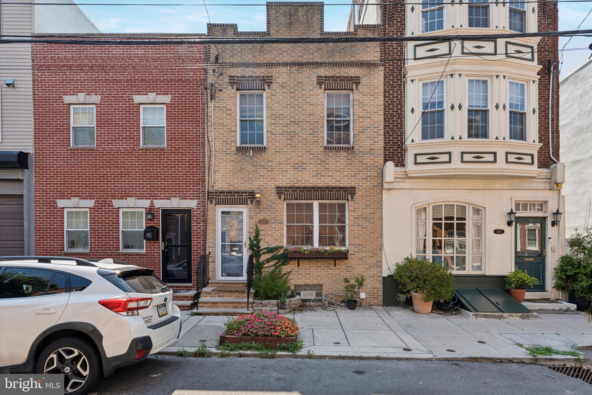 Welcome to this charming 2 bedroom, 1.5 bath home in the heart of Pennsport! Step past the inviting flower boxes on the brick front exterior to discover hardwood floors, recessed lighting, and an extra-wide first floor with plenty of space for a living area, dining table, and even a home office. The spacious eat-in kitchen is perfect for cooking and entertaining, featuring stainless steel appliances and direct access to a large patio—ideal for summer gatherings or quiet mornings with coffee. A convenient powder room completes the first floor.
Upstairs is home to two generously-sized bedrooms each with ample closet space. One boasts French doors leading to a private balcony, while the other offers high ceilings. The full hall bathroom includes a tiled tub/shower combo and is bathed in natural light from a skylight.
Situated in one of Philadelphia’s most vibrant neighborhoods, this home is just steps from local parks—including a sprayground—restaurants, nightlife, shopping, and public transportation. Commuters will love the easy access to major highways, and for added convenience, there’s a city-owned parking lot just a few doors down that is free on a first-come, first-serve basis.
Don’t miss your chance to call this Pennsport gem your own!