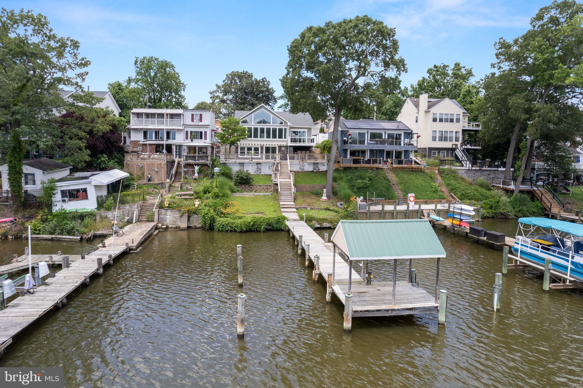 Imagine waking up to stunning water views and ending your day with cinematic sunsets – all from your custom-built waterfront cottage. Perfectly designed for a staycation, or anyone looking to downsize without compromising on luxury. This Stoney Creek gem offers a tranquil escape with every high-end detail imaginable.
Step inside and be captivated by the sun-drenched living room, featuring exquisite custom built-in bookcases, a gas fireplace, and elegant stack stone walls. The gourmet kitchen is a chef's dream, boasting high-end stainless appliances, granite countertops, under cabinet lighting, and soft-close cabinetry. Unique touches like a stained-glass corner cabinet, a convenient pantry, and an island with an additional sink elevate the space. You'll love the unique tiled backsplash map of Stoney Creek and the continuity of chauffeur ceilings and bamboo flooring flowing into the living room.
Your private sanctuary awaits in the primary bedroom, where you can wake up to picturesque water views and step directly onto the deck. The primary bathroom offers ultimate comfort with a heated floor and a spacious walk-in closet with built-ins. A second bedroom provides convenience with its own private entrance to the hall bathroom.
The upper level of the home is accessed through its own separate entrance, making it ideal for a home office or creative studio along with its built in furniture and powder room.
Outdoor living here is truly unparalleled. The lower level recreation room opens directly to your entertainment haven. The deck features a retractable awning for sunny days and a built-in projector screen for movies under the stars. The highlight is the custom outdoor kitchen, complete with a built-in grill, refrigerator, sink, and granite countertops with ample seating – perfect for entertaining! After a long day on the water, rinse off and refresh in the convenient outdoor shower before heading inside.
Beyond the entertainment, your private pier offers water, electricity, and deep water access for all your boating, fishing, and kayaking adventures. The community has a voluntary HOA where you can get access to the boat ramp.
This isn't just a home; it's your own private vacation paradise. Don't miss the opportunity to experience waterfront living at its finest!