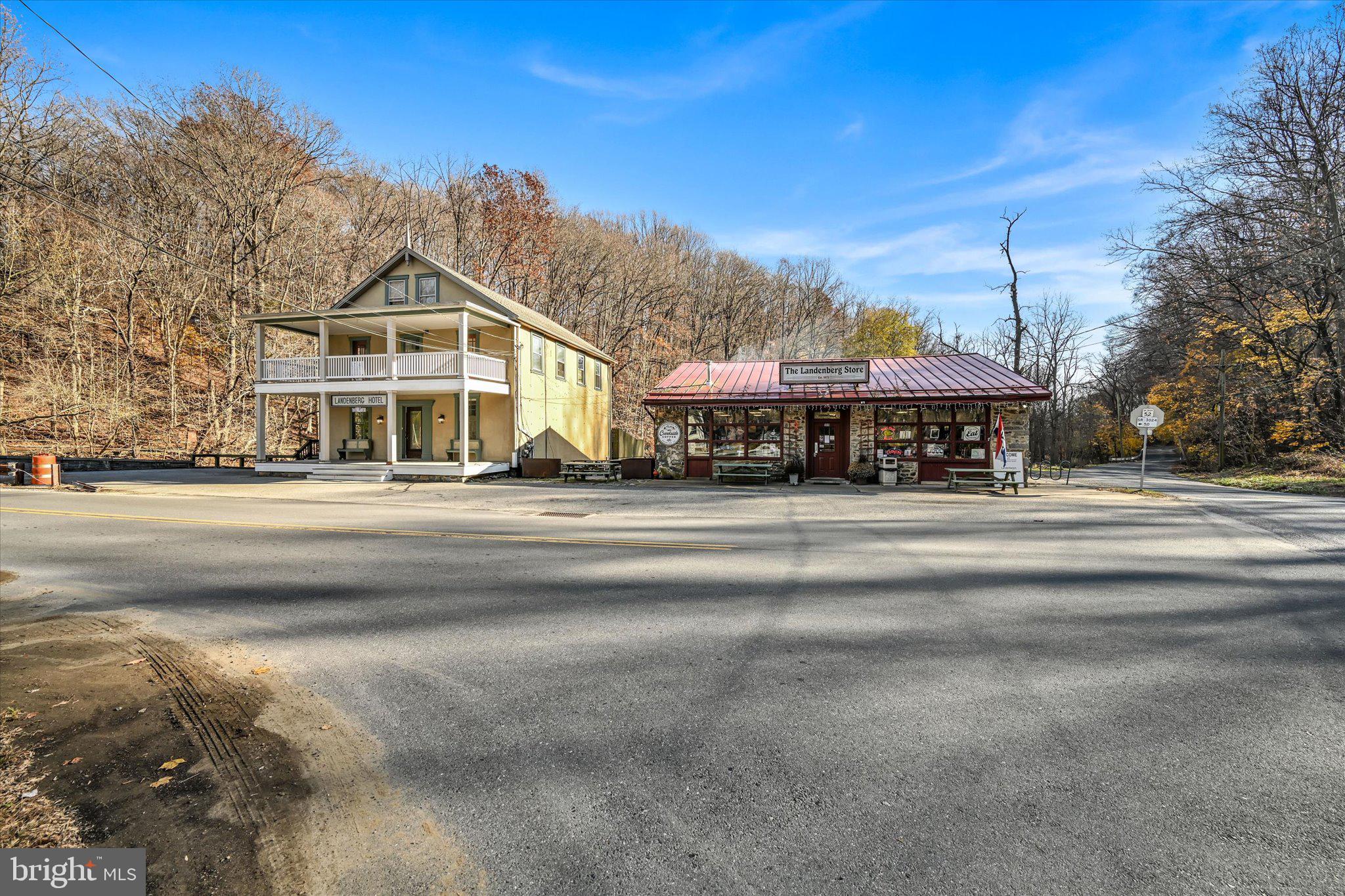 Discover the perfect blend of history, charm, and opportunity with this extraordinary property in Landenberg, PA, amongst the rolling hills of Chester County. This stunning 1872 residence has been meticulously renovated and is situated next to the thriving Landenberg Store, a beloved small-town general store. Live in a home that seamlessly combines classic old-world charm with contemporary conveniences, and operate a successful business right next door! With approximately 3,200 square feet of living space and an additional 2,200 square feet of commercial space, this property offers plenty of living space for all to spread out, and a commercial space that is well-known and cherished amongst the locals. The residence is a masterpiece of modern updates and timeless appeal. On the main floor, a beautifully designed kitchen features new stainless steel appliances, a large island with a quartz waterfall edge and barstool seating, white cabinets with glass fronts, connected to a spacious dining area with a vaulted ceiling with charming beams, surrounded by windows and sliding doors that offer panoramic views of White Clay Creek. The cozy informal family room flows into a more formal living room with a half bath, while a charming library near the entrance currently serves as a second office- wait until you see the beautiful built-in shelving! Off of the family room, accessible via a private staircase, you will find a spacious bedroom with a brand new ensuite bath. This room offers built-in custom bunk beds a convenient sink. The main staircase leads to two additional bedrooms, each with its own bath, and an upper-level deck spanning the width of the home. A private one-bedroom in-law suite with its own deck and entrance at the back of the second floor is perfect for in-laws or guests. On the third floor, the primary suite is a sanctuary, complete with a luxurious new ensuite bathroom with new tub and shower with glass shower enclosure, built-in shelving, and a blank-canvas walk-in closet space, as well as a private balcony overlooking the serene landscape. Throughout the entire residence you will find designer lighting and fixture selections, high ceilings + baseboards and intricate crown molding detail. The original hardwood flooring maintains the 1870's appeal while the other selections compliment the era seamlessly. The Landenberg Store is a well-established community hub known for its warm and inviting atmosphere and known local favorite, Creekside Coffee. The store offers breakfast, lunch, and dinner, with a menu that features specialty sandwiches, fresh baked goods, and signature items like penny candy and local ice cream. Popular with locals and visitors, the store also showcases products from local artists, hosts a free book and puzzle exchange, and serves as a resource for community referrals and friendly advice. With a loyal following of over 3,000 people on Facebook, it continues to thrive as a neighborhood favorite. Located at 100 Landenberg Road, this unique property is both a dream home and a business opportunity. Its classification as a commercial property, it presents an unparalleled chance to own a piece of Landenberg’s rich history. If you’re looking to run a successful business and enjoy life in a historic and beautifully renovated home, this property offers an incredible lifestyle in a picturesque setting, well known for hiking and biking at the nearby Landenberg Junction Trail, swimming in the creek, as well as a backdrop for a photography session- a truly beautiful nature scene surrounds you! Don’t miss out on this one-of-a-kind opportunity!