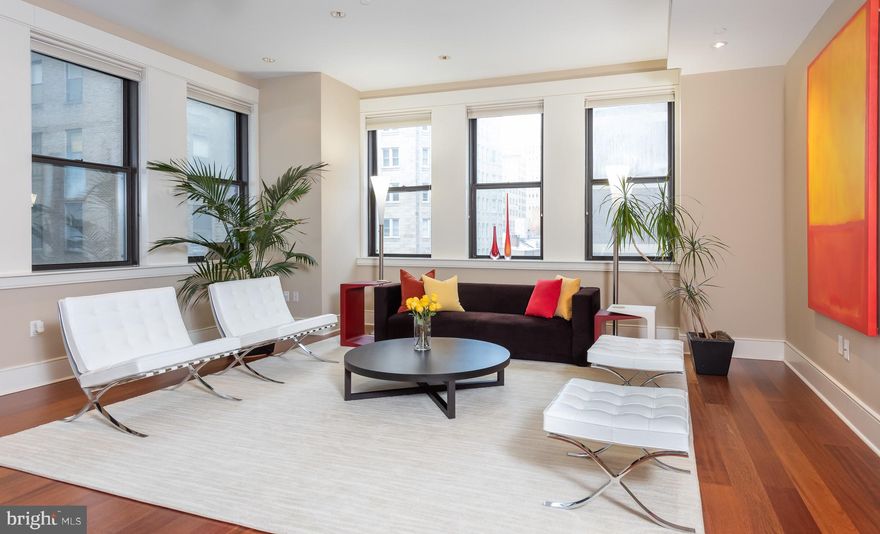 *FEATURED in Philadelphia Magazine* Open, spacious, corner unit at The Chelsea with soaring ceilings and walls of windows. This Gorgeous upgraded condominium has two (2) spacious bedrooms, two and a half (2.5) sleek bathrooms, and beautiful wide plank mahogany hardwood floors. Enter through the foyer- complete with half bath outfitted with stainless steel sink and upgraded fixtures.  Floor-to-ceiling French doors, custom stained to match the floor, lead into the custom chef's kitchen with Miele and Sub Zero appliances, and stainless steel rolling pantry door. Over-counter drop-down lighting illuminates the floating dining bar. The kitchen flows seamlessly into a large dining room / living room combo to form the ultimate great-room for optimal entertaining.  Custom-built pocket doors lead from the greatroom to the secondary bedroom suite. A custom-milled mahogany wall unit runs the entire length of the of the back wall. The room is outfitted with large walk-in closet and en-suite bath with shower and tub. The room is versatile as a result of its stunning wall unit, and at various times, it has also been used as a family room, nursery, media room, and office.A spacious closet in the hallway to foyer contains stackable washer/dryer. The master bedroom has two large closets, extra space for a desk, and the master bath is outfitted with a jacuzzi tub, separate enclosed seamless glass shower, and double vanity. Custom blinds and updated fixtures complete the condo. The Chelsea is a boutique building in the middle of Rittenhouse, near all public transportation, City Hall, Broad Street, Walnut Street, restaurants, shopping, major hospitals, and all the city has to offer. Two units per floor.