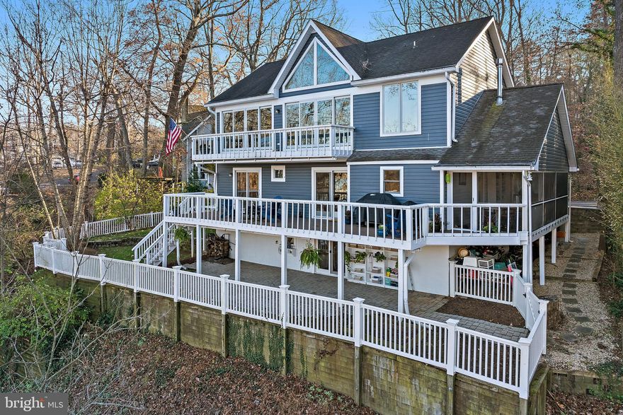 Enjoy unobstructed views of Saltworks Creek from this ideally situated home in the sought-after, water-privileged community of Severn Grove—just minutes from downtown Annapolis. Thoughtfully designed across three spacious levels, the home offers an open, light-filled floor plan that seamlessly blends everyday comfort with effortless entertaining, all defined by picturesque water views. The main level features warm wood flooring, a welcoming living room with a fireplace, and a well-appointed kitchen anchored by a large island and accented with plantation shutters. A main-level bedroom with a full bath and a separate office provide flexible living options. Step outside to multiple decks and a screened porch—perfect for relaxing or hosting while taking in the peaceful surroundings. Upstairs, three additional bedrooms include a water side primary suite with sweeping water views. A cozy library with custom bookcases and its own fireplace creates an ideal space for reading or working from home. Finishing out the second floor is a full bathroom and two bedrooms....one with water views. The fully finished lower-level lives like a private guest suite, complete with a bedroom, full bath, kitchen, spacious living area, and walk-out access—offering exceptional versatility for extended visits or multigenerational living. Additional features include off-street parking and access to Severn Grove’s exceptional amenities, including a clubhouse, beach, water access/marina, and kayak storage. With its flexible layout, scenic setting, and prime location, this home offers a rare opportunity to enjoy the best of waterfront living.