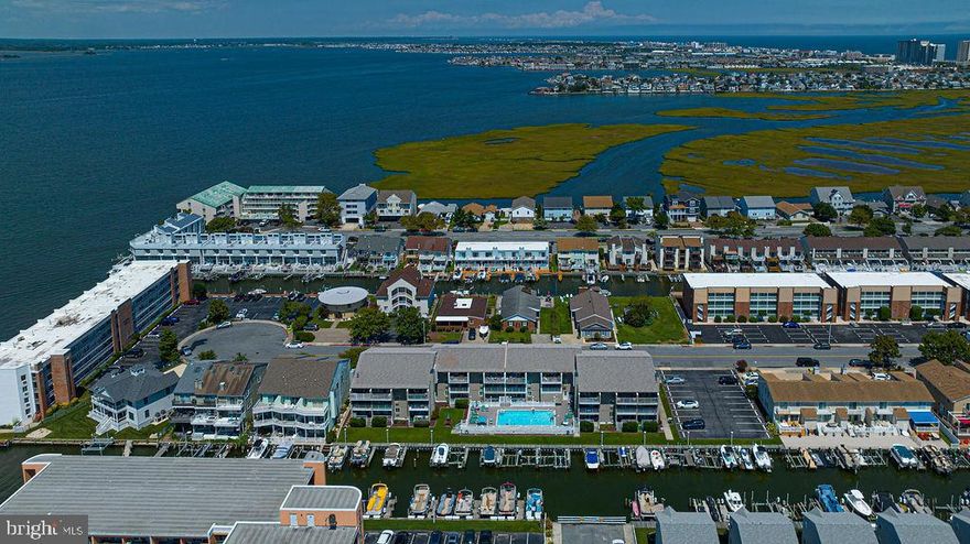 Waterfront condo with deeded boat slip and outdoor pool.  This oversized condo features a spacious floorplan and is one of the largest bayside waterfront 1 bedrooms in town.  Full size kitchen with plenty of cabinets and counter bar seating.  Large Covered deck overlooking the canal and peaks of the bay.   Very nicely furnished and ready to move in.  Over sized bedroom plus a murphy bed for extra guests and a full Size LG washer/dryer.  Building features a large outdoor pool and pool deck, parking lot plus off street parking ,low maintenance vinyl siding & low condo fees.