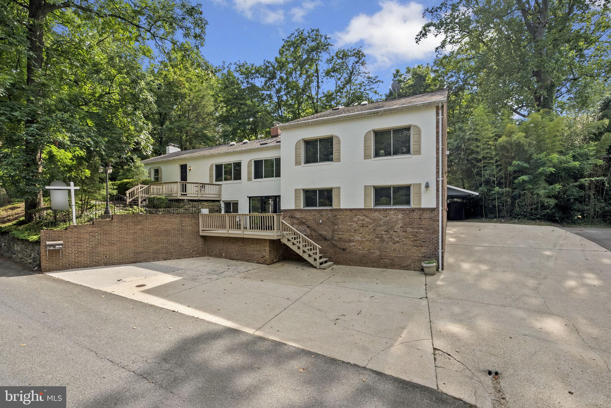 Elevate your lifestyle and business at 2816 Linden Lane, nestled in the beautiful Forest Glen Park neighborhood of Silver Spring and next to National Park Seminary. This expansive property, exceeding 5,200 sq ft, presents a unique opportunity to harmoniously blend living and working spaces, making it ideal for entrepreneurs, creatives, or multi-generational families.
The residential section exudes warmth and hospitality, showcasing elegant hardwood floors and a charming gas fireplace. It features two spacious living areas and two generously sized bedrooms sharing a well-appointed bathroom suite. The sunroom seamlessly transitions into a gourmet kitchen equipped with high-end appliances, a sizeable center island, an eat-in area, and abundant counter and cabinet space.
A slate walkway from the kitchen leads to the property's centerpiece—a stunning two-story great room with soaring 20-foot ceilings, fireplace, and a magnificent arched picture window. French doors reveal a private bedroom with an ensuite bath, a dedicated study, and a convenient laundry room.
The upstairs primary suite is a true retreat, complete with a spacious walk-in closet, ensuite bathroom, and a versatile bonus room.
The ground level, zoned R-90, offers remarkable commercial or residential versatility. With its own entrance, reception area, bathroom, multiple adaptable rooms, and parking for 8+ vehicles, it is perfectly suited for a home-based business, professional office, in-law suite, or Accessory Dwelling Unit (ADU). Additional unfinished space with large French doors opening to the backyard offers an opportunity for more office space or a large family room for the home.
Outside, enjoy mature landscaping and slate patios in both the front and back, facilitating seamless indoor-outdoor living. Additional features include an additional building with full bathroom, perfect for reimagining as an art studio or guest suite.
Experience the perfect blend of living and working in a space adapted to your needs and business — don’t miss this exceptional opportunity!