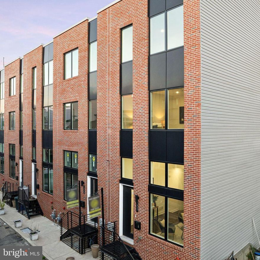 Welcome to 1327 S. Capitol Street, just a 15-minute walk to Center City! This luxury townhome offers exceptional value with 1-CAR garage parking with EV charging, modern design, and a private roof deck. Located in the Wharton Court, the premier luxury development in Point Breeze, this home features a thoughtful layout that blends open-concept living with comfort and convenience. The main living area boasts soaring 14’ ceilings, sleek glass railings, and expansive front windows that flood the space with natural light. Perched on a mezzanine level, the kitchen overlooks the living room and dining area, creating a dramatic sense of openness. Outfitted with a peninsula and high-end GE Profile appliances, it’s the perfect setup for both daily living and entertaining. Just above the kitchen, the full-floor primary suite offers an oversized bedroom that easily accommodates a king bed, a spa-inspired bathroom with a double vanity, a large soaking tub, built-in storage, a water closet, and a glass shower, plus a walk-in closet ready to be customized into the dressing room of your dreams. A half bathroom on the primary landing ensures guests never need to access your personal retreat. The top floor features two spacious bedrooms, a full hall bath with soaking tub, and a laundry room, adding additional storage. A versatile nook offers the perfect spot to put a wine or beverage fridge—ideal for entertaining on the private roof deck with stunning skyline views. Additional highlights include solid hardwood floors throughout, a finished basement that can serve as an office, gym, or second living room, smart home technology with a Google door camera, and oversized windows that enhance the home’s bright, airy feel. Ideally situated in the northern section of Point Breeze, this home offers easy access to Rittenhouse Square, Sprouts Organic Market, Giant Heirloom Market, Dock Street Brewery, ALDI, CVS, and more. Point Breeze is one of Philadelphia’s fastest-growing neighborhoods, celebrated for its vibrant dining scene, local parks, and close-knit community feel. Wharton Court places you just minutes from University City, CHOP, and I-76—all while being walkable to Center City and some of the city’s best cafes, restaurants, and shops.