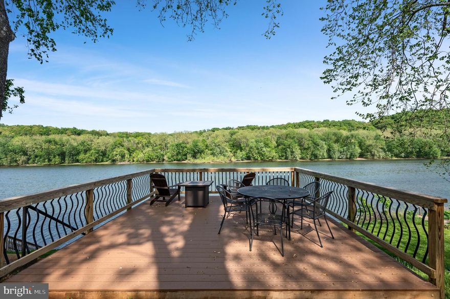 Welcome to 116 Natalie Lane, a rare riverfront retreat on the deep-water Potomac River in Harpers Ferry. Perfect as a full-time home, weekend escape, or income-generating vacation rental, this updated 3-bedroom, 2-bath rancher offers direct access to boating, fishing, kayaking, and year-round outdoor enjoyment.

Set on three lots, including two directly on the water, the home features a spacious riverside deck with a dining area, fire table lounge, and a private floating dock for your boat, paddleboards, or kayaks. An outdoor shower makes it easy to rinse off after a day on the river. Two backyard sheds offer storage for recreational gear, tools, or toys.

The enclosed sunroom is a year-round highlight, with panoramic river views, tiled floors, ceiling fans, and plenty of space to relax or entertain. Inside, a front living room opens to the sunroom, while a second living area with a wood-burning fireplace connects seamlessly to the kitchen—creating a warm, open-concept gathering space.

The kitchen is beautifully updated with stainless steel appliances, Corian counters, crisp white cabinetry, and a large island with seating for eight. The primary suite includes a private bath, with two additional bedrooms and a stylish second full bath offering space for guests.

The oversized two-car garage is finished with rubber tile flooring, a mini-split HVAC, and flexible space for a workshop, gym, or storage. Located on a quiet, low-traffic street just minutes from Harpers Ferry and less than 90 minutes from Washington, D.C., the home offers the perfect blend of comfort, access, and natural beauty.

With high-speed internet, thoughtful updates, and postcard-worthy river views, this is a standout opportunity for a riverfront lifestyle.