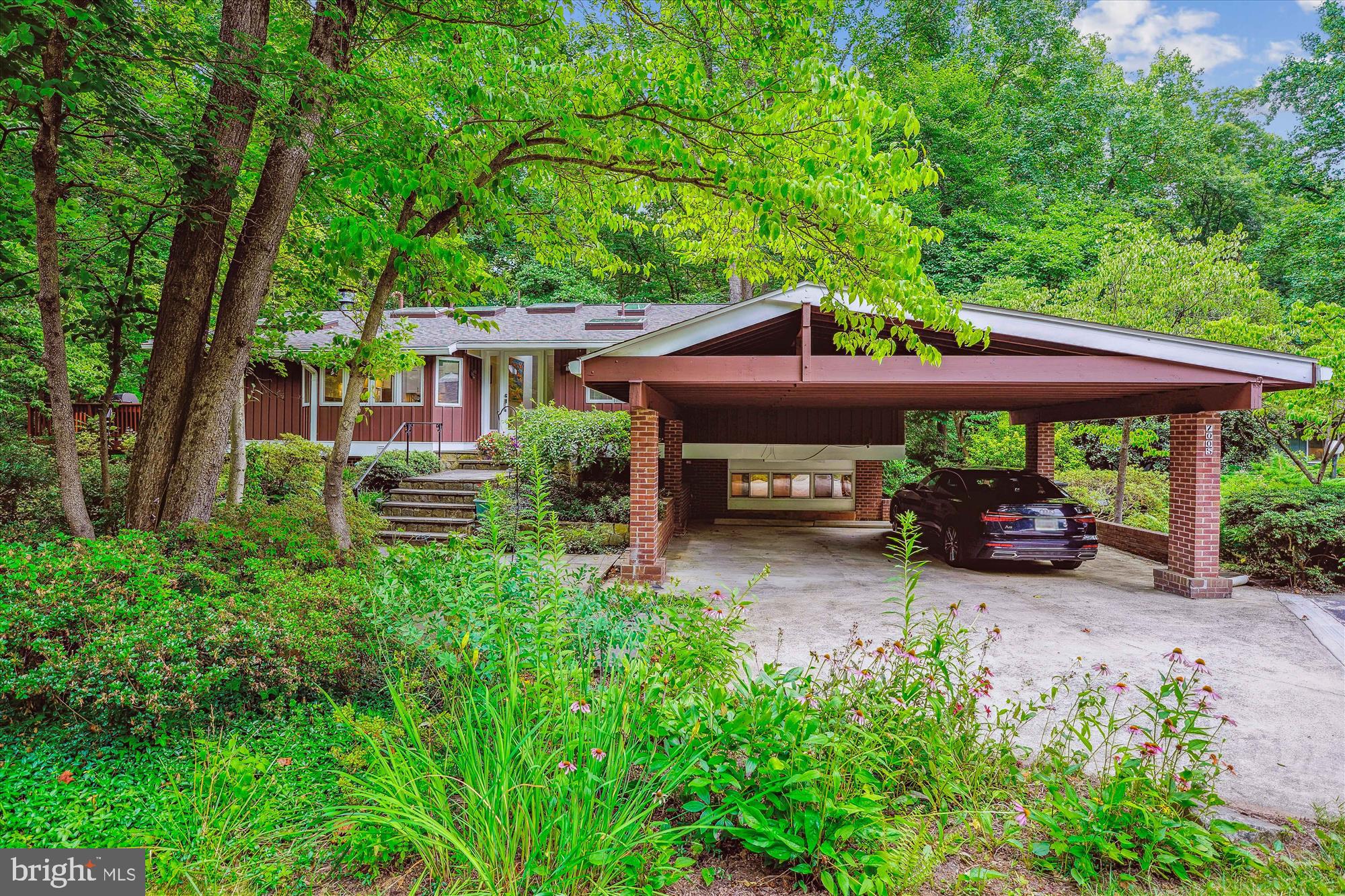 Welcome to this lovely mid-century modern Glenmore model home in the desirable Carderock Springs neighborhood of Bethesda. Located on a cul-de-sac and backing to parkland, this 5 bedroom/3 bath home offers the convenience of a main level entrance and privacy with a woodland view. The main floor is comprised of the primary bedroom and ensuite bath, along with two other bedrooms and a bath, all with cathedral ceilings. The entry foyer leads you to the pitched ceiling living room with built-ins and a wall of glass looking over the backyard. Skylights in the foyer, kitchen, dining area and baths flood the space with light. The recently remodeled kitchen has an eat-in area, high pitched ceiling and flows into the dining area surrounded by sliding doors to the large deck. The lower level consists of a spacious family room with sliding doors to the backyard and patio, fireplace, storage and laundry room, full bath and two more bedrooms, one with its own outdoor entrance and foyer which could be used as an office. A two-car attached carport and new roof further enhance this property.