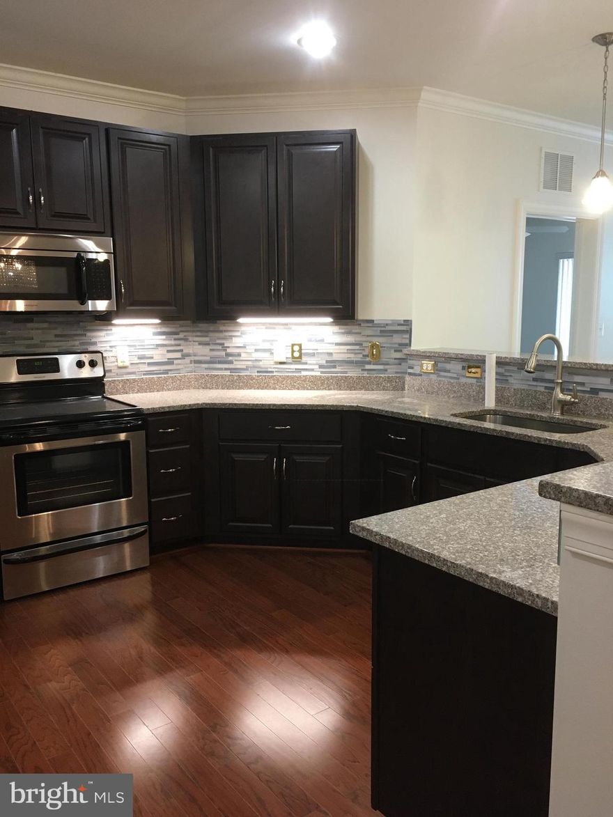 Impeccably maintained 2 bed/2 bath condo unit in a quiet,  over 55 community. Gorgeous views of the surrounding woodlands from the 2nd story balcony. Abundant closet space throughout the unit.  Freshly painted, neutral colored walls. Hardwood floors in kitchen/dining area. Neutral carpet in bedrooms and living area. Tile floors in bathrooms. Ceiling fans (with remote control) in both bedrooms. Main bedroom has a large linen closet, double sink vanity, and step-in shower with glass doors and built in bench.  Step onto the peaceful balcony from sliding glass doors in the main bedroom, or through a separate door in the living room.  Perfect for a bistro table for two to enjoy morning coffee and take in the surrounding, beautiful nature. Second bathroom has tub/shower combo.  Kitchen has stainless appliances, quartz countertops, glass tile backsplash, dark wood cabinets, and under cabinet lighting.  Laundry/Utility room with large in-unit washer and dryer provided. Nicely appointed Club Room/Exercise Room conveniently located just across the hall.  Close to elevators.  Private parking space in underground garage has room for one vehicle in addition to the lockable, fenced storage cage for additional storage.  Elevator from garage right up to your home. There is also plentiful parking in the outside lot for visitors. This is an over 55 community, meaning at least one resident must be at least 55 years old. There is a condo association which has rules to be followed. Documentation provided upon request. Unit is currently vacant and available for immediate occupancy. Credit score of at least 600 is required. Apply today!