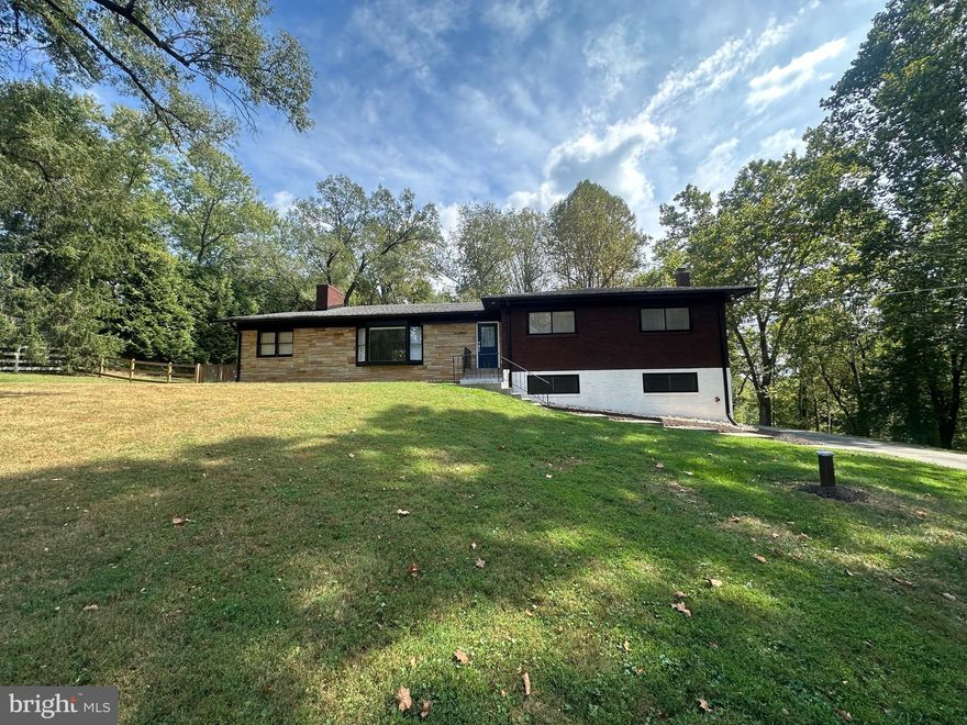 Tucked away on a quiet street, this charming detached home sits on a breathtaking 2.7-acre lot backing to the scenic Watts Branch Valley. The setting offers privacy and a peaceful, rural feel while remaining close to everyday amenities. Inside, you’ll find a thoughtfully designed and functional floor plan featuring an updated eat-in kitchen with an oversized pantry overlooking a new deck and the woods, a separate dining room, and a spacious living room with a large picture window that brings the outdoors in. The main level also includes an owner’s suite with a freshly renovated full bath, two additional bedrooms, a second full bath, and a spare office/sitting room with a double sided fireplace shared with the living room. The basement was recently renovated with a bedroom, large den with a wood burning fireplace, laundry room, and ample storage space. The lower level gets great natural light since it is a walk out, and the attached garage provides convenient parking and storage.  Recent updates throughout the home add comfort and reliability including new HVAC heat pump and ductwork, new interior water supply and sewer lines, new water heater, well water treatment system and pumps, and new 400 amp electrical service ready for an electric vehicle charging station — or, if you prefer, explore the option to build your dream home in this incredible setting. While the home is on septic, a public main sewer connection is already in place at the front of the lot with frontage fees previously paid. This home is a very special find in a special location!