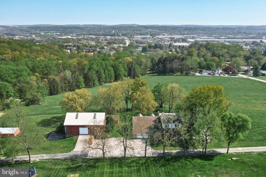 Thirteen acre farmette with stunning countryside valley view located in Springettsbury Township, York County, PA. The approximate 3,060 square foot five-bedroom Old Colonial style house with original 60’s décor includes a mid-size 50’ X 24’ bank barn circa 1853 with hayloft, three potential horse stalls, newer aluminum roof and gutters and downspouts, 24’ X 16’ hog pen and 30’ X 14’ chicken coop outbuilding. The spacious kitchen was renovated in 2013 with granite countertops, tile backsplash and wood cabinets and leads out to a large masonry covered patio where you can relax and relish the terrific views of woodlands, open fields, and the valley below. Main floor has dining room with hardwood floors, living room with fireplace (decorative only), two bedrooms with closets and a full bath with tub shower with access to the main floor laundry/mud room, an oversized two car garage with access from the living quarters and patio. The second floor offers three bedrooms all with closets, and a full bath with tub shower and double sinks. The unfinished large and roomy attic is ideal for lots of additional storage or more living space with generous ceiling height. The substantial unfinished basement offers a huge recreation room with a large fireplace  (nonfunctioning) and walk out patio to enjoy the incredible valley view. Basement has an authentic walk-in fireplace, old coal bin, well with UV system and water neutralizer, Rheem central air conditioner, natural gas fired boiler which provides hot water baseboard heat throughout the house, and sump pump. Included is a Generac 16kW home backup natural gas emergency generator. This semi-rural setting offers a short jaunt to town conveniences such as the York Galleria, York Town Center, Target, Kohls, Texas Roadhouse and much more. Enjoy other local nearby amenities such as Rocky Ridge County Park, Springettsbury Township Park, and John Rudy Park, and the York County Heritage Rail Trail. Wonderful opportunity to own this rare and unique property and enjoy those summer breezes and more. Please use caution when inside the barn due to floorboards etc. Property is in Clean and Green and crops reserved.  Please do not drive further past the house & barn as there are two other private residences and no place to turn around. All measurements are approximate and buyers responsibility to verify.