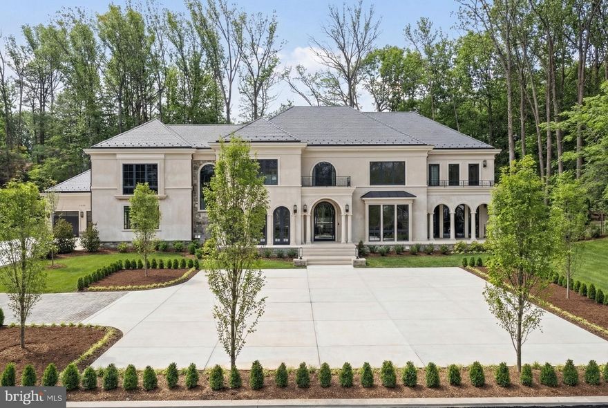 7112 Natelli Woods Lane, a stately new construction designed by GTM Architects. Envisioned as a seamless union of timeless elegance and modern luxury, this 13,000+ square foot estate rests on two sweeping acres of manicured landscape. 

A striking all-glass and steel pivot front door leads into a dramatic foyer, flanked by a formal study and grand dining room. The interiors are defined by bespoke finishes, including 9-foot Barausse Italian doors throughout, custom Italian cabinetry by Stossa Metropolis in the kitchen and bar, and meticulously tailored closets by ARAAN of Italy.

The heart of the home—an exquisite chef’s kitchen with Miele appliances—flows effortlessly into a soaring family room with 22-foot ceilings, setting the stage for refined entertaining. Ambiance is perfected by a state-of-the-art Lutron lighting system, offering over 15 million combinations, paired with custom automated Lutron shades. A butler’s pantry, scullery, elevator, and stylish powder room add convenience.
The main level features a lavish primary suite retreat with a spa-inspired bath, sitting room, and access to a covered porch. Additional highlights include a laundry room, pool bath, and five-car garage. A 30'x15' covered porch with arches, columns, heating, and a dual-sided fireplace invites all-season enjoyment with a view of the pool beyond.

Upstairs, discover five secondary bedroom suites, an optional second primary suite, and a sunlit family lounge overlooking the grounds.

The fully finished lower level is designed for indulgent recreation with a cinema, bar lounge, golf simulator, gym, billiards area, and a private guest suite.