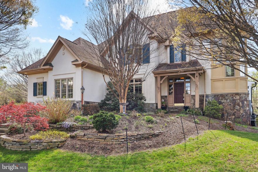 A rare opportunity in Vienna—this exceptional stucco and stone residence blends timeless design, luxury upgrades, and a fully finished walk-out lower level built for elevated everyday living. Located in the Langley High School pyramid and just minutes to Tysons, McLean, and major commuter routes, this home offers the ideal balance of privacy, convenience, and lifestyle.
From the moment you enter, you’re greeted by expansive living spaces, abundant natural light, and a seamless, open flow designed for both everyday living and entertaining. The main level is anchored by an oversized eat-in kitchen featuring extensive custom cabinetry, granite countertops with full-height backsplash, stainless steel refrigerator, double wall ovens, a gas cooktop with custom wood hood, and a large center island with seating. The kitchen opens effortlessly to a sun-filled breakfast room surrounded by walls of windows and direct access to the screened-in porch, creating a bright and inviting space that blends indoor and outdoor living. The main level also features a family room and living room, each with its own gas fireplace with blower, a formal dining room with coffered ceiling, a laundry room, and a flexible sunroom that can easily serve as a main-level bedroom with access to a full bath.
Upstairs, the primary suite offers a true retreat experience with a tray ceiling, gas fireplace, and a Juliet balcony with glass pane double wood doors that fill the room with natural light. The suite is complemented by an expansive custom walk-in closet with built-in organization. The spa-inspired primary bath is finished with high-end stonework and features a soaking tub set within a wall of windows, a large glass-enclosed shower with multiple shower heads, dual vanities with ample storage, and radiant heated floors for year-round comfort. Additional upper-level bedrooms are generously sized and offer flexible living options for guests, office space, or family needs.
The fully finished walk-out lower level is designed for versatility and entertainment, featuring a large recreation room with coffered ceilings, a fully equipped wet bar with granite countertops, cabinetry, and built-in appliances, a dedicated home theater room, fitness area, and multiple flex spaces. Walk-out access provides natural light and easy connection to the outdoor living areas.
Outdoor living is equally impressive, highlighted by a screened-in porch with a wood ceiling and ceiling fans, built with premium Pau Lope Brazilian hardwood known for its durability and resistance to the elements. The property is enhanced by extensive hardscaping including stone pathways, tiered walls, and mature landscaping, along with a full irrigation system. A rare HOA-approved storage area beneath the deck adds functionality, with structural support strategically placed to improve the view of the patio.
Additional features include four gas fireplaces, central vacuum, multi-zone audio wiring throughout, reverse osmosis water filtration, upgraded HVAC systems with humidifiers and air purification, improved insulation and air sealing, and a long-life 50-year architectural roof installed in 2011.
This home offers an exceptional combination of space, craftsmanship, and location in one of Northern Virginia’s most sought-after communities.