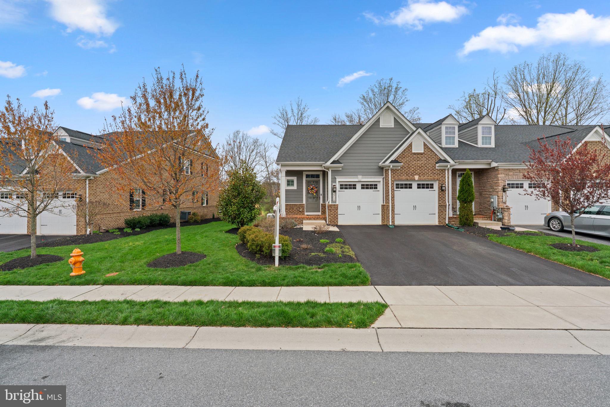 Welcome to this beautifully maintained brick-accented villa, built in 2018 and nestled in the sought-after Fairways at Turf Valley. Backing to the scenic golf course and enhanced by thoughtfully designed landscaping, this home has been lovingly cared for by its original owners. With an HVAC system installed in 2023 and updated hardwood floors gracing most of the main and upper levels, comfort and style come effortlessly.
Inside, the home showcases elegant interiors with luxury finishes, tasteful pops of color, and a layout designed for modern living. Step into the foyer, where a chic powder room sets the tone, and follow the hallway to the bright, open-concept living spaces. The gourmet eat-in kitchen is a true showstopper, featuring a large center island with pendant lighting and seating, quartz countertops, stainless steel appliances, a classic subway tile backsplash, a pantry with a Chesapeake Closets® system, and a dining area complemented by a butler’s pantry with glass-front cabinetry. Just off the kitchen, the laundry room provides convenient access to the attached garage. The living room exudes charm with an electric fireplace framed by custom built-ins, a coffered ceiling, and access to the covered porch—perfect for indoor-outdoor living. The main-level owner’s suite is tucked away through an arched hallway and offers a tray ceiling, private access to the covered porch, a spa-inspired ensuite bath with a long double vanity, an oversized shower with a built-in bench, and a walk-in closet outfitted with a Chesapeake Closets® organization system.
Upstairs, a versatile loft and bonus study area behind French doors provide ideal spaces for work or play. Two spacious bedrooms each feature walk-in closets and share a well-appointed full bathroom with double sinks. A large storage room adds extra functionality. The finished lower level expands the living space with durable LVT flooring, a walk-up exit to the backyard, a full bathroom, a flexible bonus room behind French doors, and additional storage areas.
Out back, enjoy serene views of the lush, irrigated lawn and picturesque golf course from the comfort of your covered porch—a peaceful retreat for quiet mornings or evening gatherings. The garage has been thoughtfully designed with a custom Chesapeake Closets® system as well.