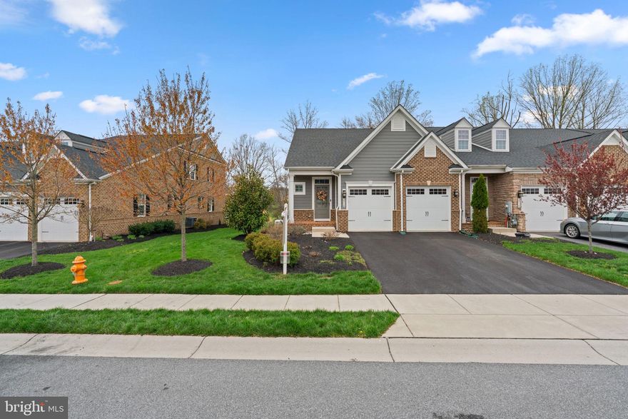 Welcome to this beautifully maintained brick-accented villa, built in 2018 and nestled in the sought-after Fairways at Turf Valley. Backing to the scenic golf course and enhanced by thoughtfully designed landscaping, this home has been lovingly cared for by its original owners. With an HVAC system installed in 2023 and updated hardwood floors gracing most of the main and upper levels, comfort and style come effortlessly.

Inside, the home showcases elegant interiors with luxury finishes, tasteful pops of color, and a layout designed for modern living. Step into the foyer, where a chic powder room sets the tone, and follow the hallway to the bright, open-concept living spaces. The gourmet eat-in kitchen is a true showstopper, featuring a large center island with pendant lighting and seating, quartz countertops, stainless steel appliances, a classic subway tile backsplash, a pantry with a Chesapeake Closets® system, and a dining area complemented by a butler’s pantry with glass-front cabinetry. Just off the kitchen, the laundry room provides convenient access to the attached garage. The living room exudes charm with an electric fireplace framed by custom built-ins, a coffered ceiling, and access to the covered porch—perfect for indoor-outdoor living. The main-level owner’s suite is tucked away through an arched hallway and offers a tray ceiling, private access to the covered porch, a spa-inspired ensuite bath with a long double vanity, an oversized shower with a built-in bench, and a walk-in closet outfitted with a Chesapeake Closets® organization system.

Upstairs, a versatile loft and bonus study area behind French doors provide ideal spaces for work or play. Two spacious bedrooms each feature walk-in closets and share a well-appointed full bathroom with double sinks. A large storage room adds extra functionality. The finished lower level expands the living space with durable LVT flooring, a walk-up exit to the backyard, a full bathroom, a flexible bonus room behind French doors, and additional storage areas.

Out back, enjoy serene views of the lush, irrigated lawn and picturesque golf course from the comfort of your covered porch—a peaceful retreat for quiet mornings or evening gatherings. The garage has been thoughtfully designed with a custom Chesapeake Closets® system as well.