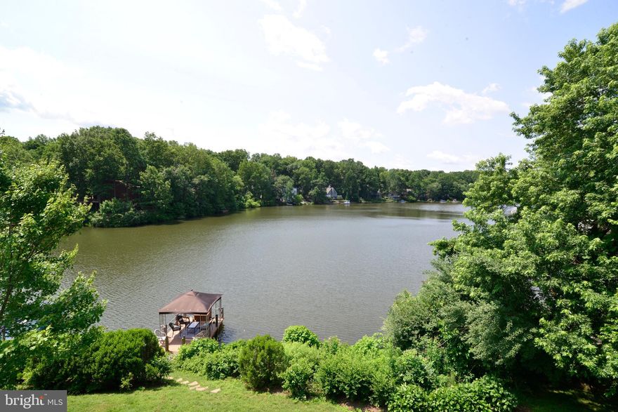 Enjoy amazing waterfront views from this beautifully-maintained, end-unit townhome perfectly situated on Reston's Lake Audubon!  This cedar and brick home offers a private setting, great space and natural light, and plenty of outdoor living space as well.  The main level has hardwood floors throughout, and there are two sliding glass doors leading to the main level deck with incredible water views.  The deck wraps around to the side of the home and features a hot tub.  There is also a glass French door off of the living room which leads to the side deck and hot tub.  The living room has great built-in cabinetry, a fireplace and recessed lighting.  The living room opens to the dining room and offers an open floor plan.  The kitchen is open to the main living area and features stainless steel appliances, granite counters and backsplash, upgraded cabinetry, a table-space dining area and a sliding door leading to the front flagstone patio.  Even the kitchen enjoys views of the water with the open walls and raised ledge! The upper level features two bedrooms,  two bathrooms and hardwood floors continue on this level.  The owner's suite has two sliding glass doors leading to a private deck/balcony with beautiful, open views of Lake Audubon.  The owner's suite also features a fireplace, built-in bookcases, a walk-in closet with built-ins, and a sitting area with lake views. The owner's suite bath has been beautifully updated with double vanity sinks, built-ins, a glass-enclosed shower, and a separate soaking tub.  The second bedroom on this level has a built-in workstation and also features chair rail and crown mouldings.  The fully-finished, walk-out lower level offers more great space with a recreation room with ceramic tile floors, recessed lighting and a sliding glass door leading to the lower level deck, lawn and lake.  There is also a large storage closet on this level, which is perfect for storing kayaks, canoes, gardening supplies and deck items.  The third bedroom is also on this level, which also features a sliding glass door to the deck.  The laundry/storage room is also on this level, but there is also a "hook-up" for a laundry closet on the upper level, in case you want to move the laundry upstairs.  The two-car garage has custom, built-in cabinetry, a charging station, and an additional workshop space.  This is a great spot on the lake with incredible water views to enjoy throughout the year.