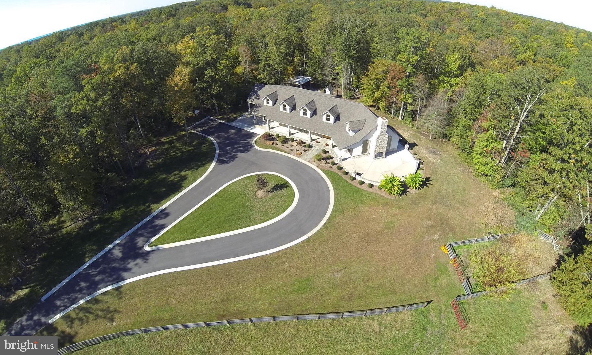 Custom built home on 16 + acres of privacy!!! No expense spared on construction or materials. Stone front & foundation, 2 x 6 construction. Pella windows, oversized hardwood on main level. Open floor plan with 24' ceiling in great room. Stone fireplace. Gourmet kitchen features custom cabinets by Pat Woddburn, granite counters w/ two breakfast bars, Stainless appliances, 6 burner gas stove with griddle. Two master suites w/ one on main level. Upstairs has 4 bedrooms, 2 baths, kitchenette & separate access from upstairs deck. Custom trim thru out. 15 x 13 walk in closet has custom walnut built ins. Dual zone HVAC. Over 500 sq ft of covered porch that leads to 48 x 26 patio & 2nd stone fireplace. Slate walkways. Paved circle driveway with concrete curbs. Conditioned crawl space. Beautifully landscaped. 60 x 40 shop that has 16 ' ceilings & 14 x 12 doors & water and separate electric meter. Fenced pastures. Pole barn. 12 x 16 tool shed. Additional perc. Great hunting, natural berm area for target practice. Perfect for horses or cattle. Plenty of space for gardens. Great place to entertain.