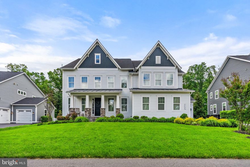 Welcome to your new perfect home! Nestled in the highly desired Greens Village of Willowsford, this immaculate NV Home, Stratford Hall Model, defines modern luxury. A blend of contemporary design mixed with high-end details and finishes to create a comfortable and stylish space. Some main features of this stunning home include an entertainer's dream outdoor space with covered patio and outdoor kitchen, an open floor plan with wide plank French Oakwood floors, a main level bedroom with private en suite, a finished basement with rough ins for a wet bar, plantation shutters and much more. Upon entering this home, you will notice the meticulous design and attention to detail with the custom wood trim, crown molding, framing along the windows, doors, and entryways throughout. The builder did not leave one stone unturned. As you step into the wide foyer to the left you will find your personal home office with custom built-in shelving and updated light fixtures.  To your right will be an incredible dining room that includes classic shadow box accent walls, 6' crown molding, and upgraded modern chandelier. 
As you make your way into the kitchen/family room area, you will notice the 24' high coffered ceilings, shadow box accent walls, and a floor to ceiling stone accent gas fireplace in the family room that truly shows off the beauty of this home. A chef's dream gourmet kitchen accompanied by floor to ceiling cabinetry, an expanded kitchen island, stainless steel appliances, quartz counter tops, subway tile backsplash, deep farmhouse sink, updated pendant lighting, a spacious breakfast nook, butler's pantry with glass cabinetry and walk-in pantry closet.  Other main level areas include a spacious mud room, a powder room, and three car garage. Make special family memories in the pristine outdoor space featuring conservancy trees to the rear of the property for privacy or entertain guests with the outdoor kitchen featuring a stainless-steel grill and refrigerator or enjoy nights around the fire with the built-in fire pit.  As you walk upstairs to the bedroom level you find four bedrooms with each room having its own en suite bathroom.   Relax and unwind in the massive primary suite that includes two huge his and hers walk-in closets, a sitting area, and huge spa-like owner's bathroom. The primary bathroom offers dual vanities, an expanded shower with bench, large soaking tub, and private wash closet. Be astonished by the size of the finished walk-out basement that offers rough-ins for a wet bar, plenty of space for large gatherings, and a huge storage area with built-in storage shelves. The massive basement recreational area allows for multiple functional areas such as game area, exercise space, theatre room, craft space, and much more! Willowsford offers some of the finest amenities including 2 resort style community pools, The Boat Lodge, The Sycamore House, miles and miles of hiking and biking trails, a splash pad park for the little ones, state of the art fitness center, an archery range, a zip-line playground, multiple dog parks, seasonal community sponsored events, and much more! Don't miss this incredible opportunity.