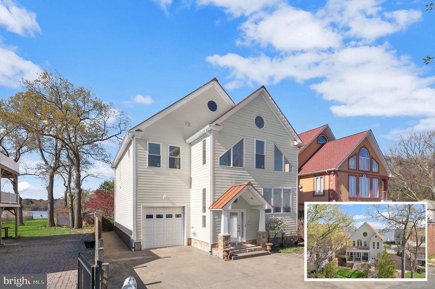 Spectacularly positioned between two serene bodies of water, this exceptional residence in the Bayside Beach community captures sweeping views of the Chesapeake Bay in the front and Boyd’s Pond to the rear, offering a rare dual-waterfront lifestyle. A private pier across the street extends into the Bay and invites endless days on the water, while expansive windows throughout the home frame breathtaking views from nearly every room.
Inside, a freshly painted interior enhances this custom home’s light-filled ambiance, complementing the warmth of hardwood flooring that flows seamlessly across the main level. The spacious living room is both inviting and refined, featuring a cozy stone-accented fireplace and tall windows that showcase the ever-changing water views. Just beyond, a combined dining area creates a natural transition into the heart of the home, the kitchen.
Designed for both everyday living and entertaining, the gourmet kitchen is a standout with its 6-burner Viking range and hood, wall ovens including a warming oven, dual islands including one with a prep sink and butcher block top, granite countertops, and a full suite of high-end appliances. These include a custom cabinet-panel SubZero refrigerator and freezer, two Fisher and Paykel cabinet-panel dishwashers that blend seamlessly with the cabinetry, an ice maker, and a SubZero wine cooler. There is also a toe-kick outlet for the Central Vacuum system. Positioned at the rear, the kitchen opens to a wall of glass doors and windows overlooking the landscaped backyard and Boyd’s Pond, with direct access to a covered Trex deck that invites effortless indoor-outdoor living. A stylish powder room with a striking blue glass vessel sink completes the main level, while the tandem garage, accessible from both front, rear, and kitchen, offers space for up to three vehicles or a boat with trailer, enhanced by its high ceiling.
The first upper level is dedicated to the luxurious primary suite, where a private sitting room with a wet bar creates the perfect retreat, ideal for morning coffee or unwinding beside the multi-sided fireplace, which can also be enjoyed from the spa-inspired bath. Here, a multi-jet soaking tub, dual vanities, tiled shower with custom glass door, and dual walk-in closets provide comfort and convenience, while the bedroom itself features a cathedral ceiling and a stunning wall of windows overlooking the Bay. A second bedroom with Bay views and a walk-in closet is served by a full bath with a custom marble counter vanity and tranquil pond views, while a spacious laundry room with sink and cabinetry adds everyday ease.
A spiral staircase leads to the third bedroom, highlighted by a 5-foot round window framing picturesque pond views. Outdoors, the landscaped backyard is enhanced with a sprinkler system in both the front and rear yards, perennial garden beds, and a curated collection of trees including weeping willow, Magnolia, Japanese maple, and crepe myrtle. The space is further complemented by a covered deck and a custom tiki hut with power and a built-in bar tap, along with wired speakers that enhance the outdoor setting, while the home itself is also equipped with wired speakers for integrated sound throughout.
Additional updates include recently replaced windows, new carpeting throughout, and a new pier installed in 2022. Residents enjoy access to Bayside Beach community amenities, including beaches, marina, boat ramps, playground, basketball court, and pavilion, enhancing the appeal of this truly remarkable waterfront retreat.  Canoe included in the sale! Please note: photos depicting furniture have utilized virtual staging.