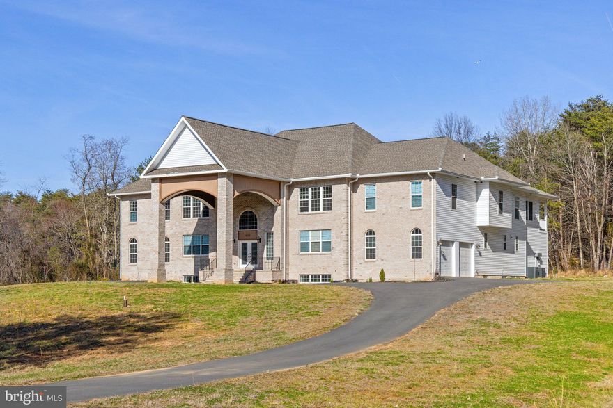 NEW PRICE!! Spectacular custom home built in 2021 on 2.85 acres surrounded by trees with no HOA!  The grand sweeping staircases welcome you into the flowing, open floor plan with 12,531 finished sq ft on three levels!  This expansive and luxurious home offers four large bedrooms upstairs, each with their own private full bathroom, plus a bedroom and full bathroom on the main level!  The Owners Suite features a sitting room, two-sided electric fireplace, private rear balcony, and two walk-in closets.  The sumptuous primary bathroom shines with marble flooring, two separate vanities and countertops, a center tub with jets, and a walk-through Roman shower with two shower heads!  Entertain in the enormous gourmet kitchen with marble flooring, granite counters, stainless steel appliances, and oversized center island!  The fully finished basement includes a great room with walk-behind bar, plus four finished bonus rooms for crafts, hobbies, home theater, or home gym!