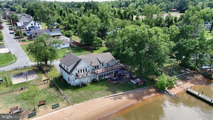 Best of everything on the water. Build you own dock or ask about the possible deep water community boat slips. Community boat ramp. You will own a private sandy beach 100 feet wide off your deck. No better views anywhere. Total of five bedrooms and three full baths. Finished en suite  above garage with separate entrance and full bath.  Oversized garage with full garage doors on both ends.  Beautiful hardwood floors. All glass front overlooking beach and water. There is a very open concept on first floor with open staircase. Huge deck on first and second floor. Lots of new updates inside. Home being sold as is.