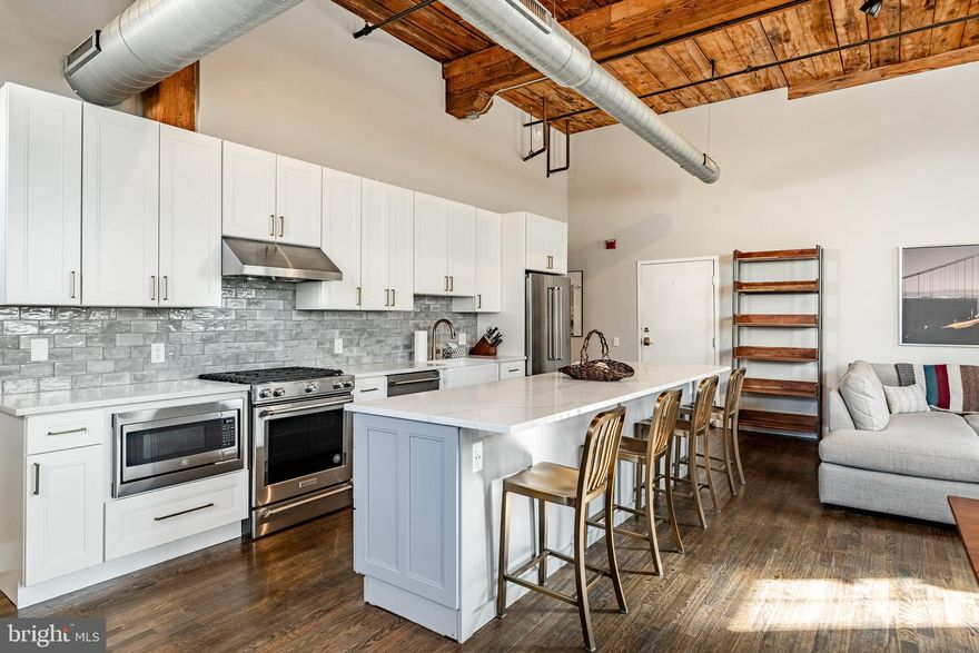 This stunning 2BR / 1BA loft, meticulously renovated by its previous home builder & designer/owner, is ideally situated just a few blocks from the heart of Manayunk’s Main Street. Housed in a historic textile mill, this exceptional space combines contemporary design with industrial features, offering a rare and stylish living experience. As the standout unit within the 9-unit Felt Works building, it boasts its own private entrance, direct access to secured, climate-controlled parking at the rear, and a generously open living space.

Inside, you'll be captivated by 20-foot ceilings, large arched windows, exposed brick and stone walls, and freshly refinished oak floors that flood the loft with natural light. The open concept kitchen is a true centerpiece, featuring an oversized 11-foot island, sleek Calcutta quartz countertops, and classic white shaker cabinetry. Equipped with premium KitchenAid appliances, including a farmhouse sink and gleaming brass fixtures, this kitchen is designed for both function and style. The open-concept layout allows for flexible use of the space and creates an entertainers dream. 

The master bedroom offers ample space for a king-sized bed and includes two closets, one of which is a spacious walk-in. The second bedroom provides plenty of options depending on your needs, making it perfect for a home office, guest room, or nursery. The newly updated bathroom features dual entry, from both the master and the hallway, for added convenience. It includes a combined shower and tub, a 60-inch double-sink vanity, and a laundry/linen closet. Stylish shiplap walls, exposed beams, and brass accents add to the loft’s refined design.

The home is outfitted with high-end details throughout, including solid wood doors and trim. Located just steps from Manayunk’s best dining, shopping, and trails, with a quick 15-minute drive to downtown Philadelphia, this loft offers the perfect balance of historic character and modern luxury. A must-see property!