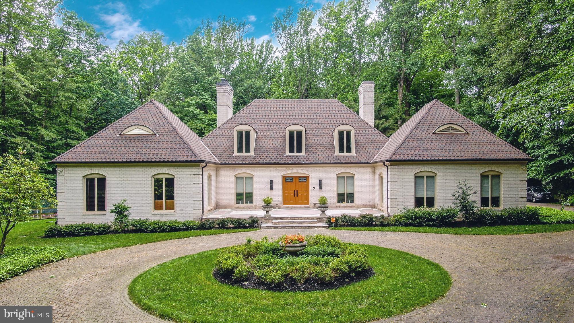 Welcome to 2422 Velvet Valley Way—an exceptional residence nestled on over 2.3 private acres in one of Owings Mills’ most coveted communities. This stately, all brick French Manor style home has been thoughtfully updated and meticulously maintained, offering over 6,000 sq ft of beautifully appointed living space designed for luxurious comfort, entertaining, and everyday ease. From the moment you arrive, the home’s impressive curb appeal and circular drive set the tone for what’s inside. Step through the front door into a grand two-story foyer flooded with natural light from overhead skylights. To the right, a gracious formal living room with gleaming hardwood floors offers the perfect setting for quiet gatherings or celebrations alike. The dining room with custom cabinetry is truly designed for hosting wonderful family gatherings, holiday meals and both large or intimate dinner parties. At the heart of the home is the gourmet kitchen, featuring granite counters, stainless appliances, 2 dishwashers, double wall ovens, an oversized refrigerator, custom cabinetry, a breakfast bar for quick meals "on the go", and a spacious center island - ideal for meal prep. The adjoining breakfast area is filled with sunlight and overlooks the scenic backyard, which is accessible through sliding glass doors. The kitchen opens seamlessly into the family room, where built-ins and a electric fireplace create a warm and inviting space for cozy nights, movie marathons, or game-day celebrations. Just off the kitchen, the mudroom/laundry area provides practical organization and leads to a private guest bedroom and full bath—perfect for visiting guests or an au pair suite. To the left of the foyer, the primary bedroom wing serves as a private sanctuary, featuring an expansive primary suite with exceptional dual walk-in closets and a luxurious en suite bath complete with heated floors, a jetted tub, oversized walk-in shower and separate vanity area. An additional bedroom, full and half bath, and a dedicated office with built-ins are thoughtfully situated in this wing, creating an ideal balance of privacy and functionality. On the upper level, you’ll find two generously sized bedrooms that share a full bath. Each enjoys direct access to a large private balcony—ideal for morning coffee or evening relaxation while overlooking the rear yard. Luxurious carpet and oversized closets with custom built-ins continue throughout this level. The fully finished lower level is as versatile as it is spacious, offering a large recreation area, home theater zone or game room and a professionally outfitted fitness room with padded flooring and a mounted TV—all equipment conveyed at no charge to the buyer. There’s also a separate workshop, utility/storage room, and additional space to customize as you wish. Step outside to your private resort-style backyard, where you will find exquisite hardscaping, a large covered stone patio, the in-ground saltwater pool with adjacent spa (conveyed as-is) and fire pit, all surrounded by lush landscaping and creating an idyllic, serene space for year-round enjoyment. Whether to host parties or unwind, this is The Space! Sports enthusiasts will love the tennis/sports court—ideal for friendly matches well into the evening or to convert to a future pickleball court! Additional outdoor highlights include a side-entry two-car garage, a spacious circular driveway with lighted welcome pillars & lamps and an additional brick drive for extra parking. ** NEW ROOF in 2024. In 2020: replaced BOTH HVAC systems, 1,500 gallon SEPTIC TANK, 1,000 gallon PROPANE TANK, UPDATED ELECTRIC PANELS, 73 gallon propane WATER HEATER, WELL WATER FILTRATION SYSTEM. In 2021: Generac WHOLE HOUSE GENERATOR, pool resurfaced. In 2023: Upper level mini split system installed. ** This location is close to shopping, dining, Greenspring Station, Foundry Row, top private and public schools, and major routes including I-695 and I-83.