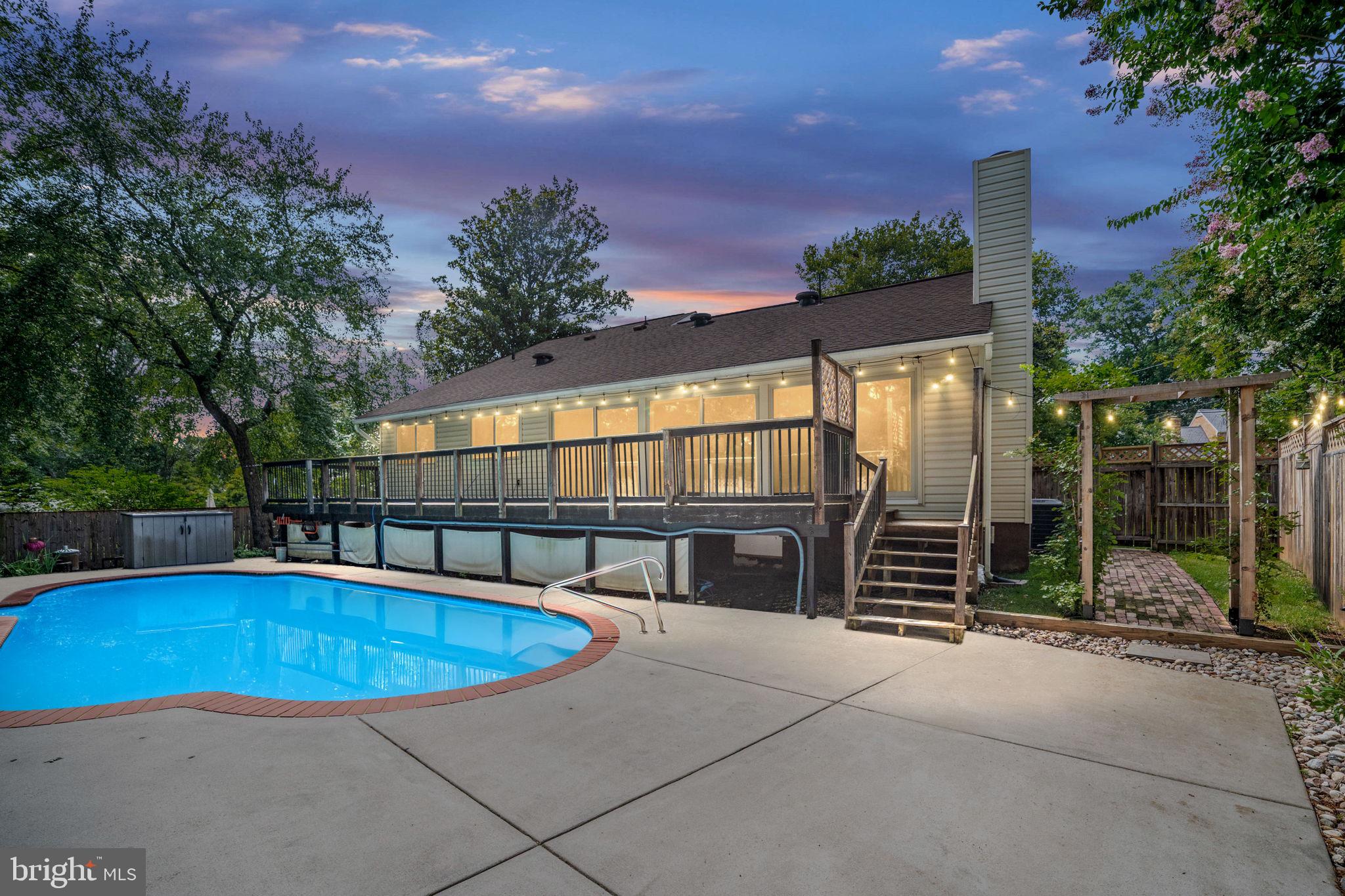 Welcome home to Stratford Landing! Nestled on land once part of the original George Washington Farm, this stunning mid-century modern home offers an extraordinary blend of timeless architecture, luxurious custom updates, and resort-style outdoor living—all in one of the most sought-after neighborhoods along the Potomac River. From the moment you arrive, this home sets itself apart with striking curb appeal and a beautifully considered design. Step inside through a dramatic blue granite entryway and into a bright, open floorplan filled with natural light, vaulted ceilings, and refined finishes. Bamboo hardwood flooring flows throughout the main level, accented by reclaimed barnwood planking and thoughtfully curated details at every turn. The sunken living room is both stylish and inviting, featuring a gas fireplace with a custom wrought iron and reclaimed barn beam mantle, remote-controlled blackout shades, and recessed lighting. From here, the home flows effortlessly into the elegant dining area with a designer light fixture and into the spacious family room—where a breathtaking wall of windows overlooks the backyard oasis. Anchored by an oversized fireplace with gas logs, the family room is flooded with sunlight year-round and connects seamlessly to the expansive rear deck via three 8-foot sliding glass doors. At the heart of the home, the centralized kitchen has been extensively updated with granite countertops, high-end custom tile backsplash, an oversized farmhouse porcelain sink, and stylish pendant lights, offering both beauty and function. With motion-activated lighting, cedar wine racks, and a beverage refrigerator they’ve really thought of everything. On the other side of the home, discover three rare main level bedrooms, all generously sized with ample closet space., plus a beautiful private bathroom attached to the primary bedroom and a second full bathroom in the hallway.. Upstairs, the expansive loft includes three large closets and an en suite bathroom, offering additional flexibility for a private in-law or nanny suite or quiet home office. Step outside and experience your own private oasis—where every element has been designed for relaxation, beauty, and unforgettable gatherings. A wide rear deck stretches the full length of the home, offering the perfect perch to take in the view of your beautifully landscaped backyard. Follow the brick walkway past lush river rock flower beds and onto the expansive concrete pool deck, where a sparkling heated in-ground swimming pool invites you to unwind or entertain in style. A winding flagstone path adds charm and structure to the space, all fully fenced for privacy and peace of mind. Whether it’s quiet mornings with coffee or lively summer evenings by the pool, this outdoor retreat is truly something special. This home is not only beautiful but smartly equipped, with modern conveniences such as a custom security camera system, keyless door entry, built-in garage shelving and mounted bike racks, and a 4-car concrete driveway. Notable recent updates include a new water heater (2024), HVAC system (2016), pool pump (2024), and pool cover (2019). Stratford Landing offers a rare combination of history, community, and convenience—just minutes to Safeway, Hollin Hall Shopping Center, Costco, Old Town Alexandria, Fort Hunt Park, Mount Vernon, Cedar Knoll, and the Mount Vernon Trail. Commuters will love easy access to the GW Parkway, Huntington Metro Station, Lorton VRE, I-95, I-495, and Fairfax County Parkway—along with close proximity to Fort Belvoir, INOVA Mount Vernon, and The Pentagon. This is a rare opportunity to own a beautifully updated, light-filled mid-century gem in a prime location. Schedule your private tour today—and enjoy the rest of the summer poolside!
