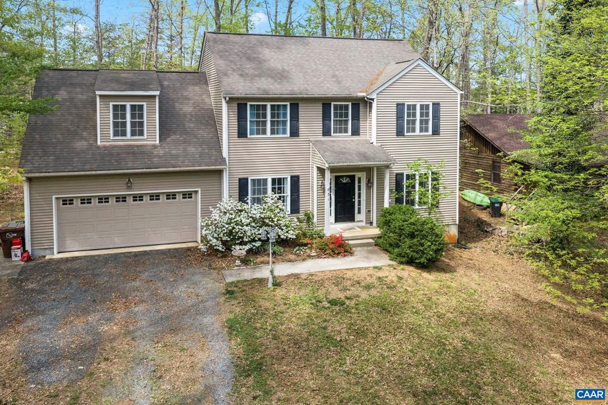 Great value! Priced under tax assessment, this Lake Monticello colonial is conveniently located near the main gate. The main level offers wood flooring throughout, a spacious living area with a gas fireplace, a separate dining room, and a kitchen that opens to a breakfast area. A rear deck off the kitchen overlooks a level backyard. Upstairs, the primary bedroom includes a walk-in closet and private bath. Three additional bedrooms offer flexible use, including one oversized room that could function as a bonus room or additional living space. A walk-up attic with permanent stairs provides substantial storage. Located within walking distance to community amenities including the pool, clubhouse, and tennis courts.,Wood Cabinets,Fireplace in Living Room