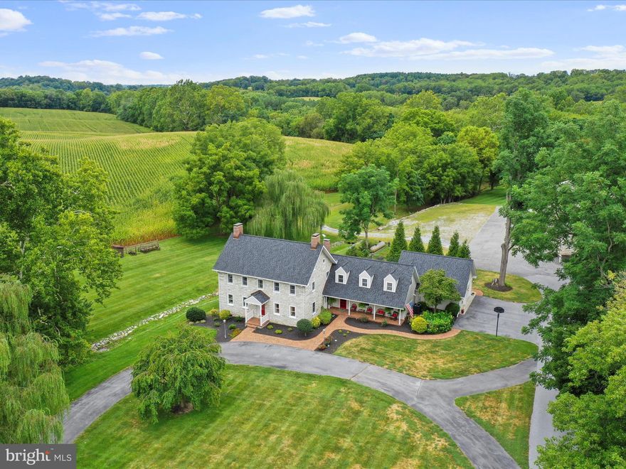 Welcome to an extraordinary opportunity to own a piece of early American history—The Christian Newcomer Home, an exquisite 5-bedroom, 3-bath stone farmhouse dating back to 1795. Nestled on 20 pristine acres, this meticulously maintained estate seamlessly combines timeless craftsmanship with modern luxury.
Inside, discover original barnwood flooring throughout, lending warmth and authenticity to every room. The living room and sitting room each feature classic wood-burning fireplaces, perfect for cozy evenings. A formal dining room invites elegant entertaining. 
A chef’s dream kitchen awaits with a Wolf gas range, Sub-Zero refrigerator, quartz countertops, pantry, island with breakfast bar, and additional casual dining space—seamlessly connected to a large family room for easy everyday living.
Two separate staircases lead to the second level, offering access to three spacious bedrooms. The luxurious primary suite includes its own gas fireplace, private entrance to an oversized walk-in closet room and a spa-style bath with jetted tub, double sinks, and separate shower. The third floor offers two additional bedrooms, perfect for guests, office space, or a quiet retreat.
A screened-in porch leads to a hardscaped patio and chlorine-treated in-ground pool—an idyllic setting for relaxation or entertaining. Adding to the charm, a natural spring runs through the basement, creating a truly unique and rare natural feature.
Additional property highlights include: A massive 2-bay barn converted into office space with two private rooms, storage, and an attached 2-car garage. Separate corn crib and donkey barn. A charming 3-bedroom, 2-bath tenant house perfect for guests, rental income, or multigenerational living. 
With unmatched historical significance, luxurious finishes, and stunning surroundings, this one-of-a-kind estate invites you to live a life of timeless beauty and comfort.