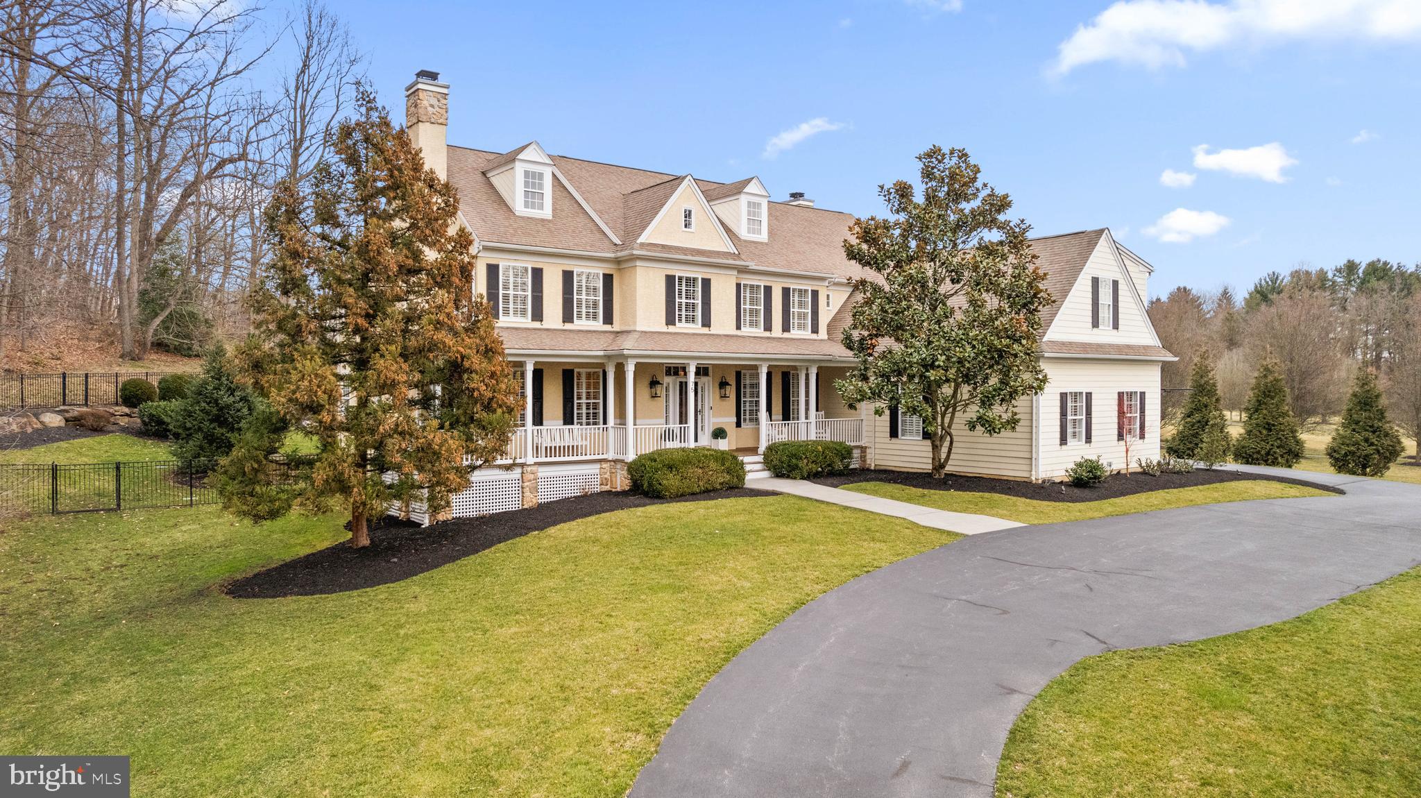 Treasure the ambience and serenity of this spectacular 5,000+ square foot one-of-a-kind Country Manor located in Chester County’s coveted Willistown Township. The circular driveway leads to a custom, delightfully inviting wraparound porch which is neatly accented by tongue and groove wood ceiling. Once inside, the breathtaking interior features a front to back hardwood floored Reception Hall, formal Living Room (gas fireplace with custom millwork), and Dining Room (including stunning built-in cabinetry). The sunny and airy Kitchen and Family Room have both undergone recent renovation. Removal of walls and archways has provided an open concept layout. Finishing touches include upgraded millwork, stone countertops, custom backsplash and stainless-steel appliances. The step-down Family Room includes a beamed ceiling, encased Palladian Window providing a view to the lush backyard, and a gas fireplace flanked by a custom built in cabinet. The remainder of the main level consists of a dedicated Home Office with custom cabinetry, formal and informal Powder Rooms, Main and Rear Staircases, side entrance to the Mud Room with beadboard wainscoting, ceramic Tile Floor and Garage access (three car, new carriage style garage doors, epoxy floor, drywalled and painted). If there is a “not to be missed” here, it’s the spacious all-season outdoor entertainment sanctuary with direct access from several rooms. Enjoy the inviting Stone Fireplace, easy care stamped concrete floor, recessed lighting and sound system speakers. Just beyond, you’ll be drawn to the In-Ground Pool (constructed by well-known TED’s Pools) and professionally landscaped lighted grounds which provide absolute privacy as you enjoy your summer retreat in your own back yard.
On to the second floor, five well-proportioned Bedrooms and three full Baths provide privacy for everyone. All secondary Bedrooms offer new carpeting, updated ceiling fans, and direct access to Jack and Jill Baths. The fifth Bedroom would make a perfect Nanny Suite, with its separate living space, while the king-bed-sized Main Bedroom offers hardwood floors, tray ceiling, a sitting area and double walk-in closets with pocket doors. In the ensuite primary bath find a Jacuzzi Tub, separate vanities, roomy shower stall and marble tile. The Laundry Room is conveniently located on this level with two Washers and two Dryers included.
The well-appointed finished basement provides room for games, sports, entertainment, and exercise. It includes a Home Gym/Play area, custom built-in cabinetry with bookshelves, TV area, Wet Bar (cherry floor, ice maker, under cabinet lighting), Game Room (Pool Table and accessories included), and full Bath with direct access to the Work-Out/Play area. A separate unfinished storage area with shelving and additional gaming space are neatly proportioned and add to the utility of the lower level.
The current owners have spared no expense or thought in renovating, maintaining and embellishing this amazing Tag-built residence. Additional noteworthy features include Plantation Shutters on all windows (even the garage), a whole house Generator, freshly painted rooms, several windows replaced (Andersen), new carpeting, two zone updated HVAC, new Hot Water Heater and a Rain Soft water softener. There is so much to offer and so much to love in this gorgeous ‘Southern influenced’ custom home.
